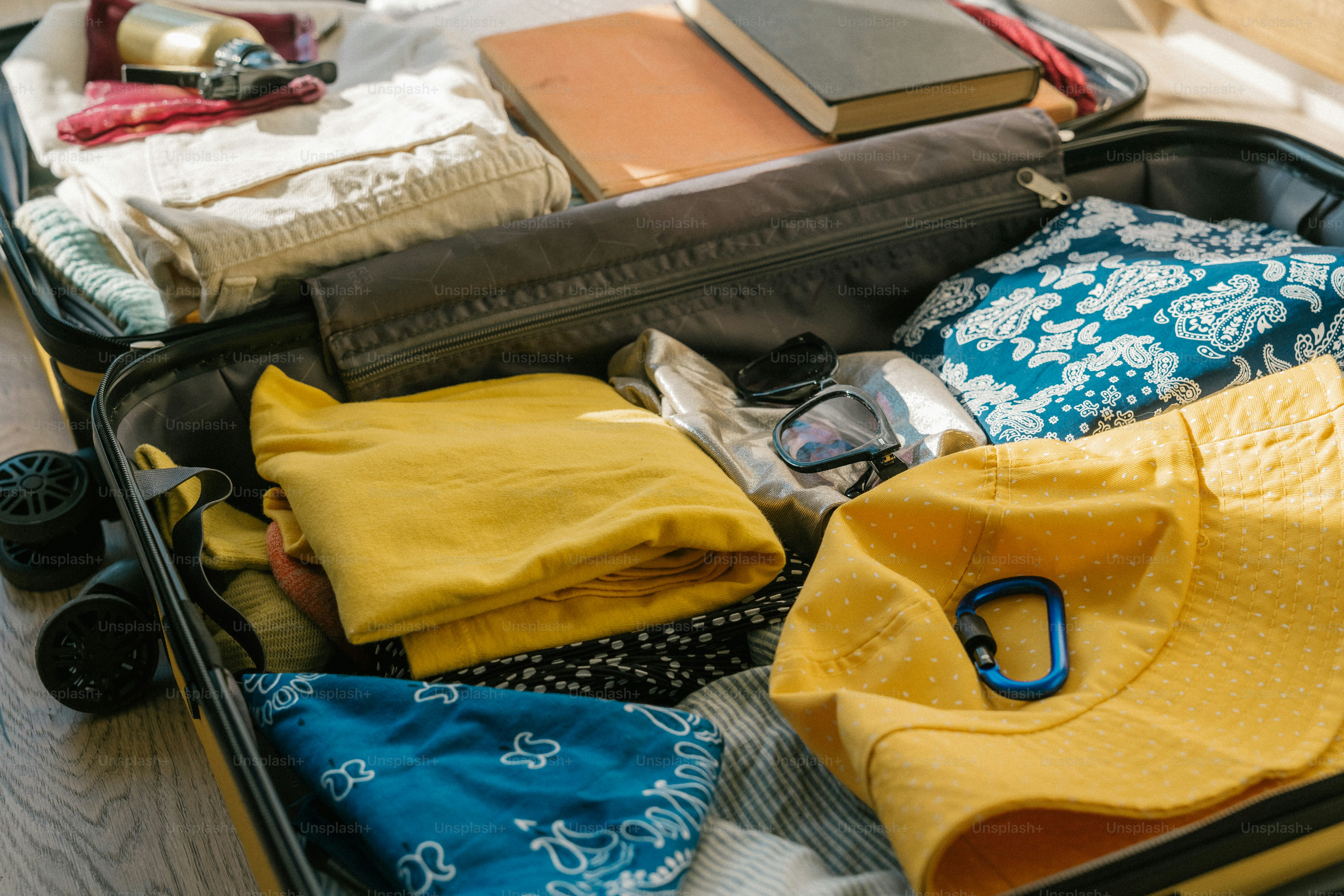 Suitcase packed with clothes and books for travel.