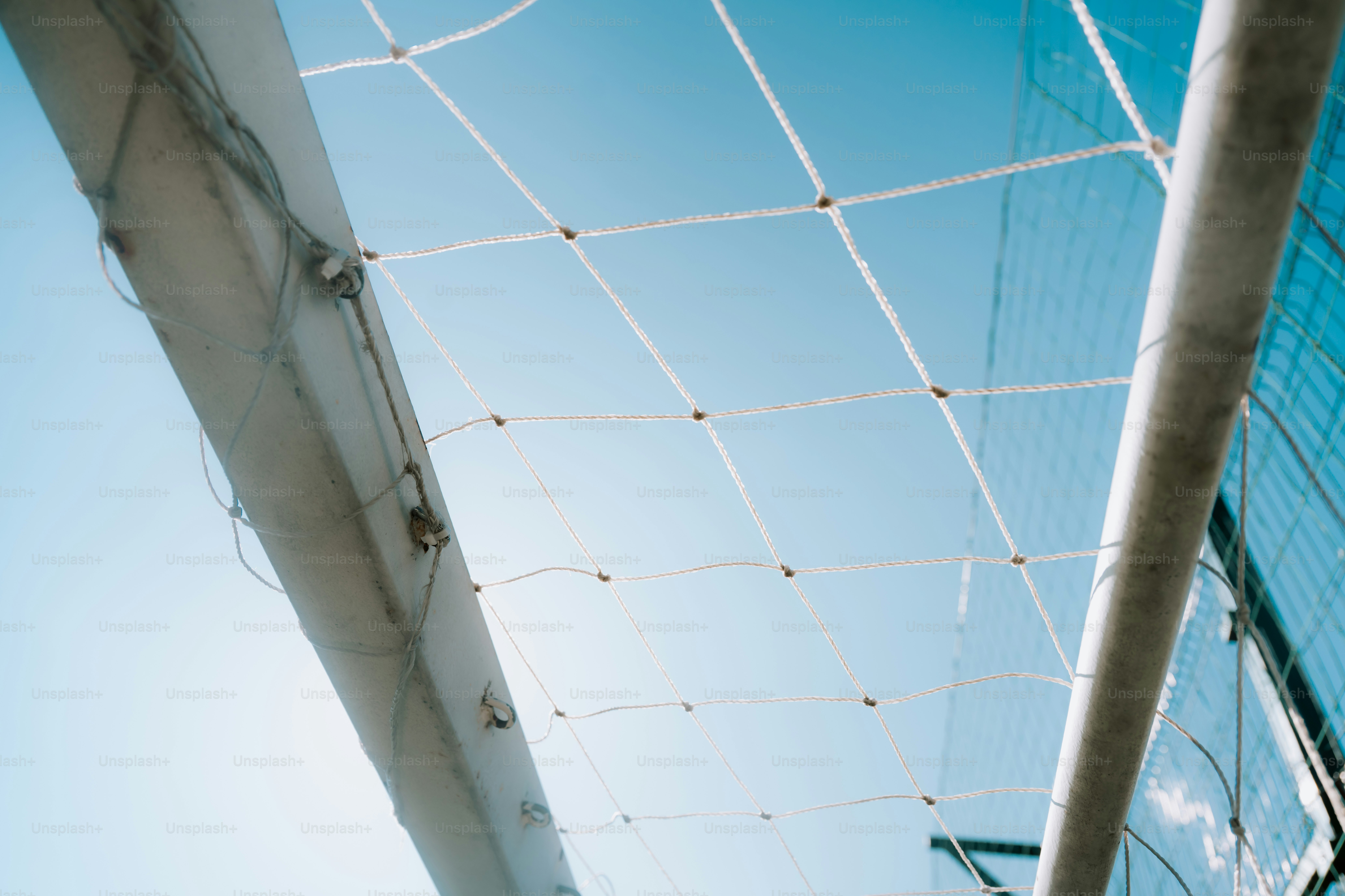 Soccer goal net against a clear blue sky