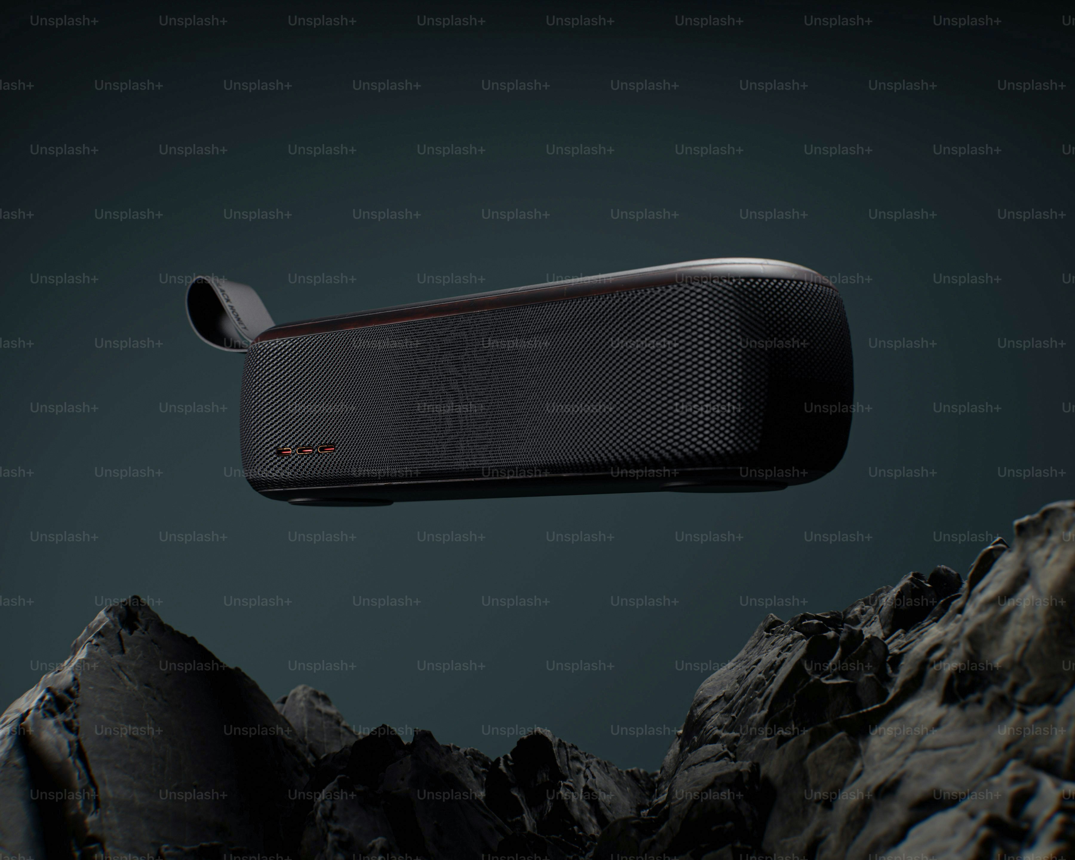A black portable speaker floats above rocky terrain.