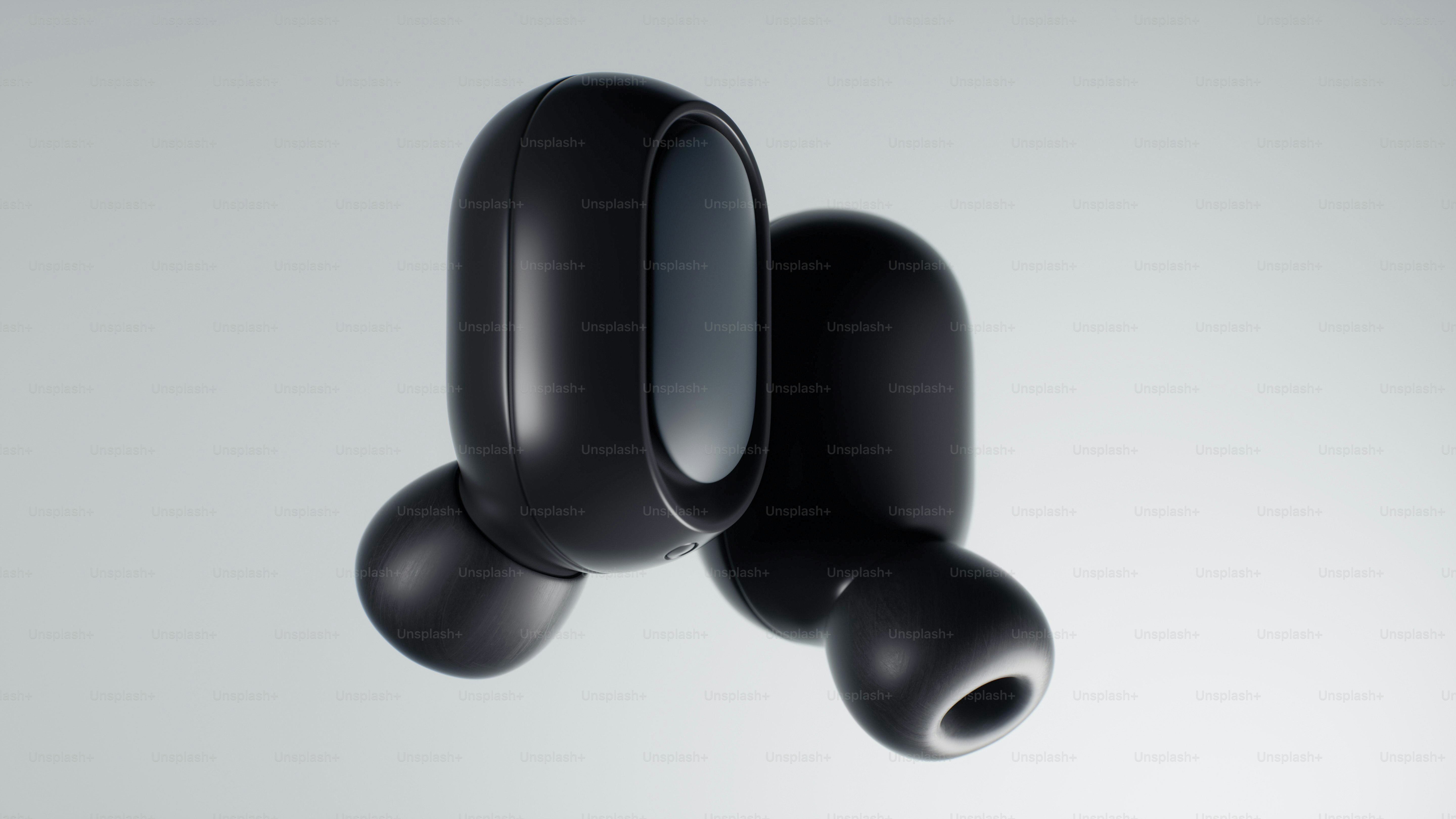 Two black wireless earbuds on a light background