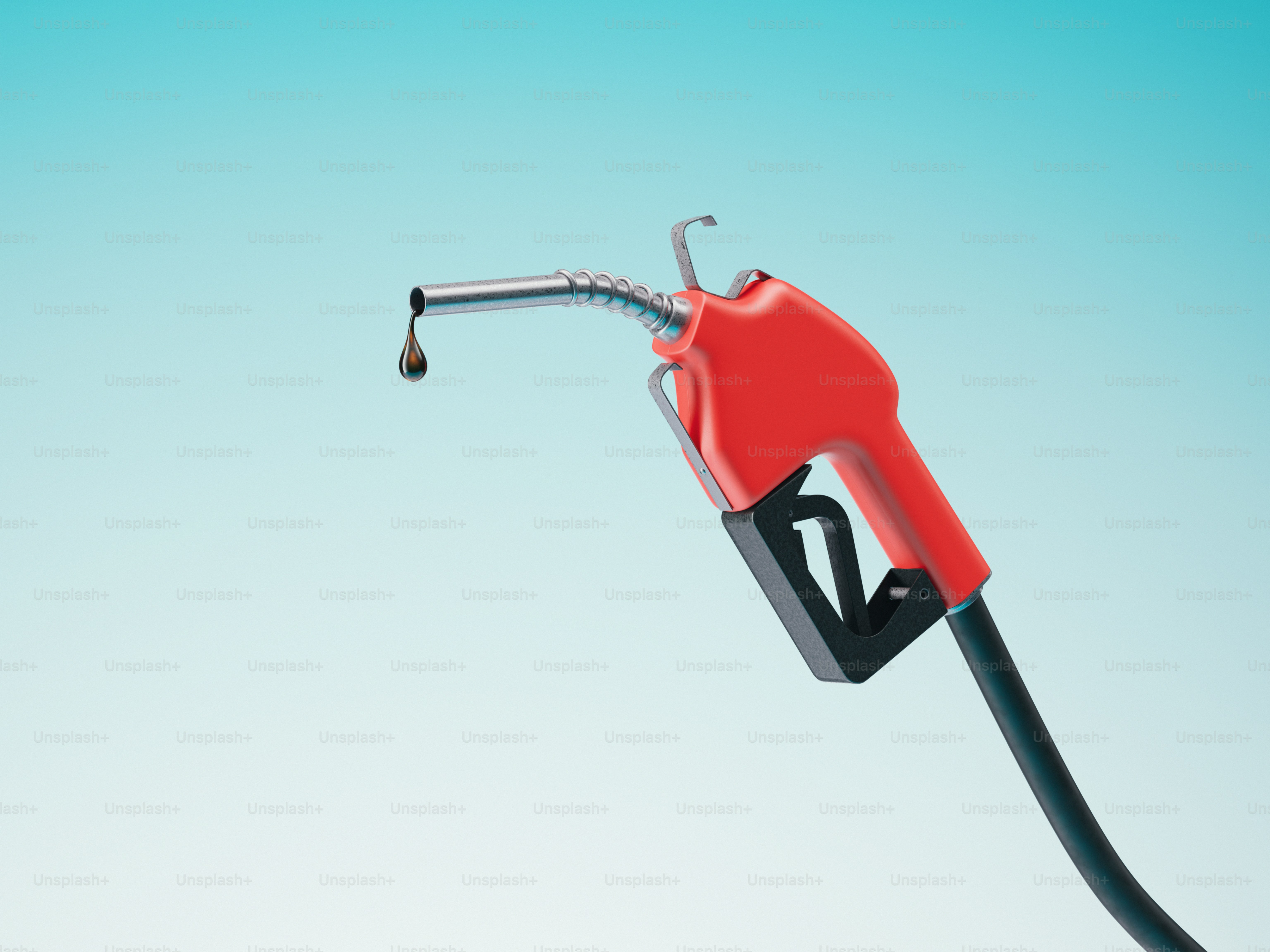 A red gas pump nozzle with a drop of fuel.