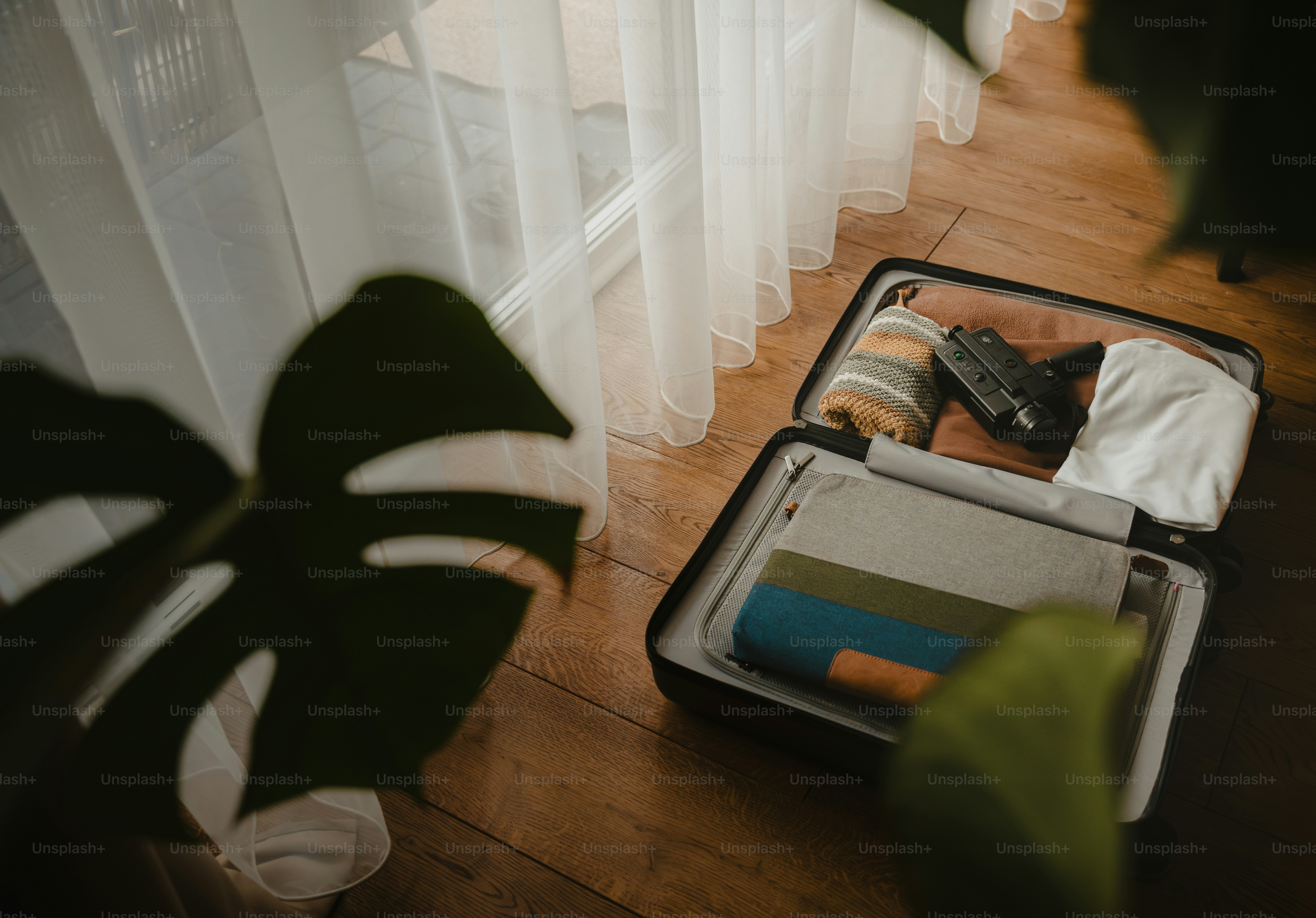 Abre la maleta llena de ropa y artículos de viaje.