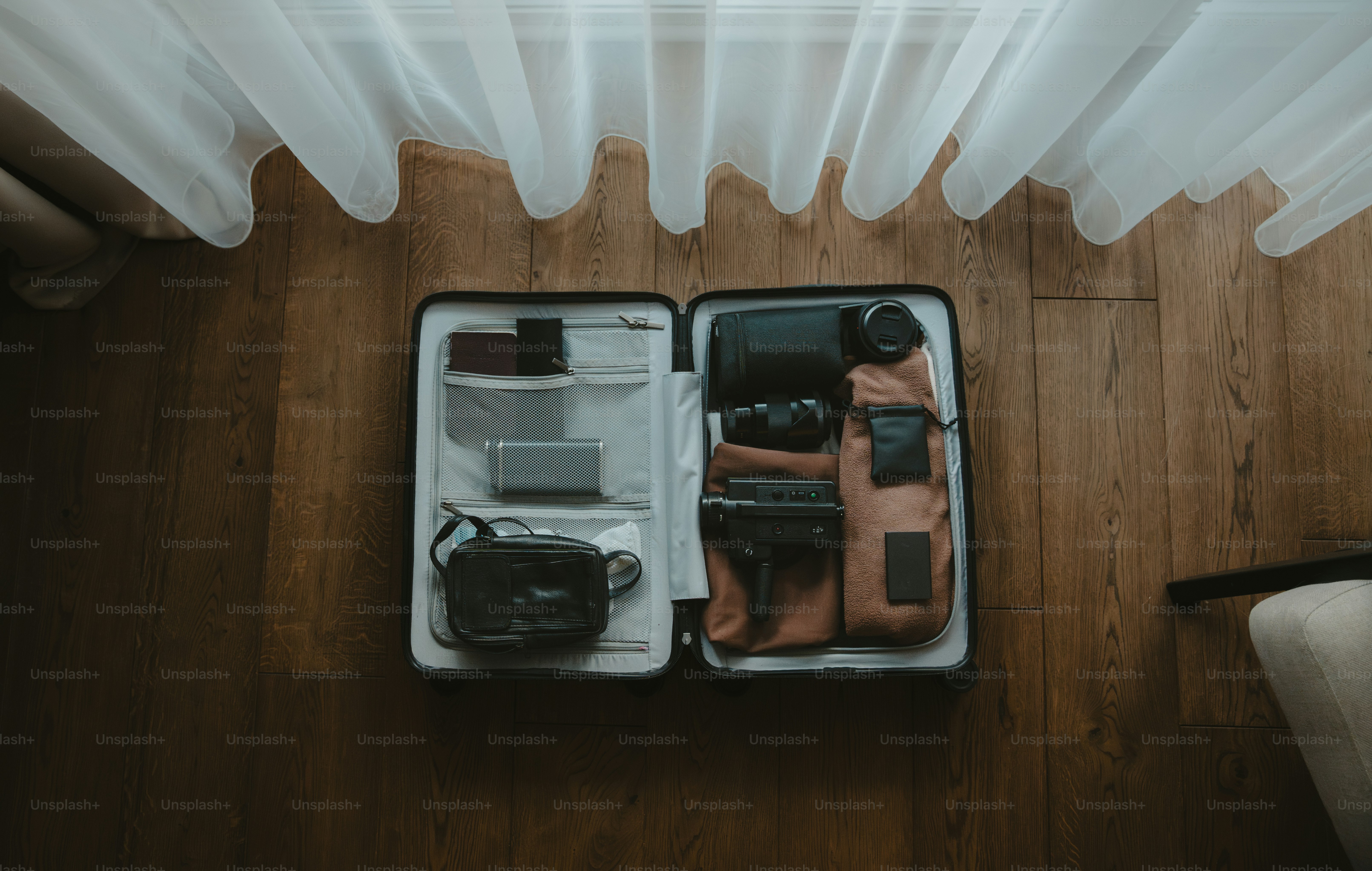 Abre la maleta llena de material fotográfico y artículos esenciales para viajar.
