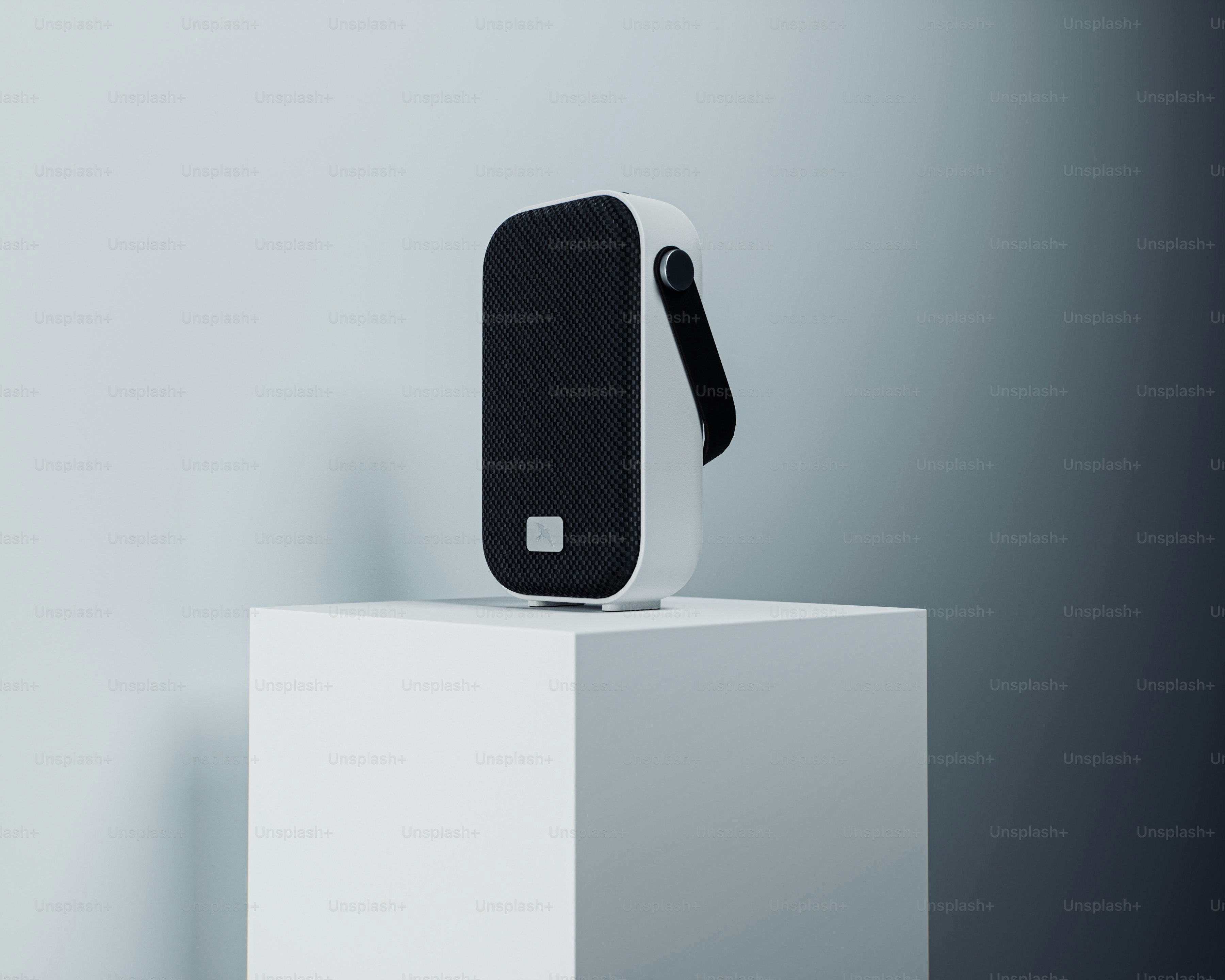 A white and black portable speaker on display.