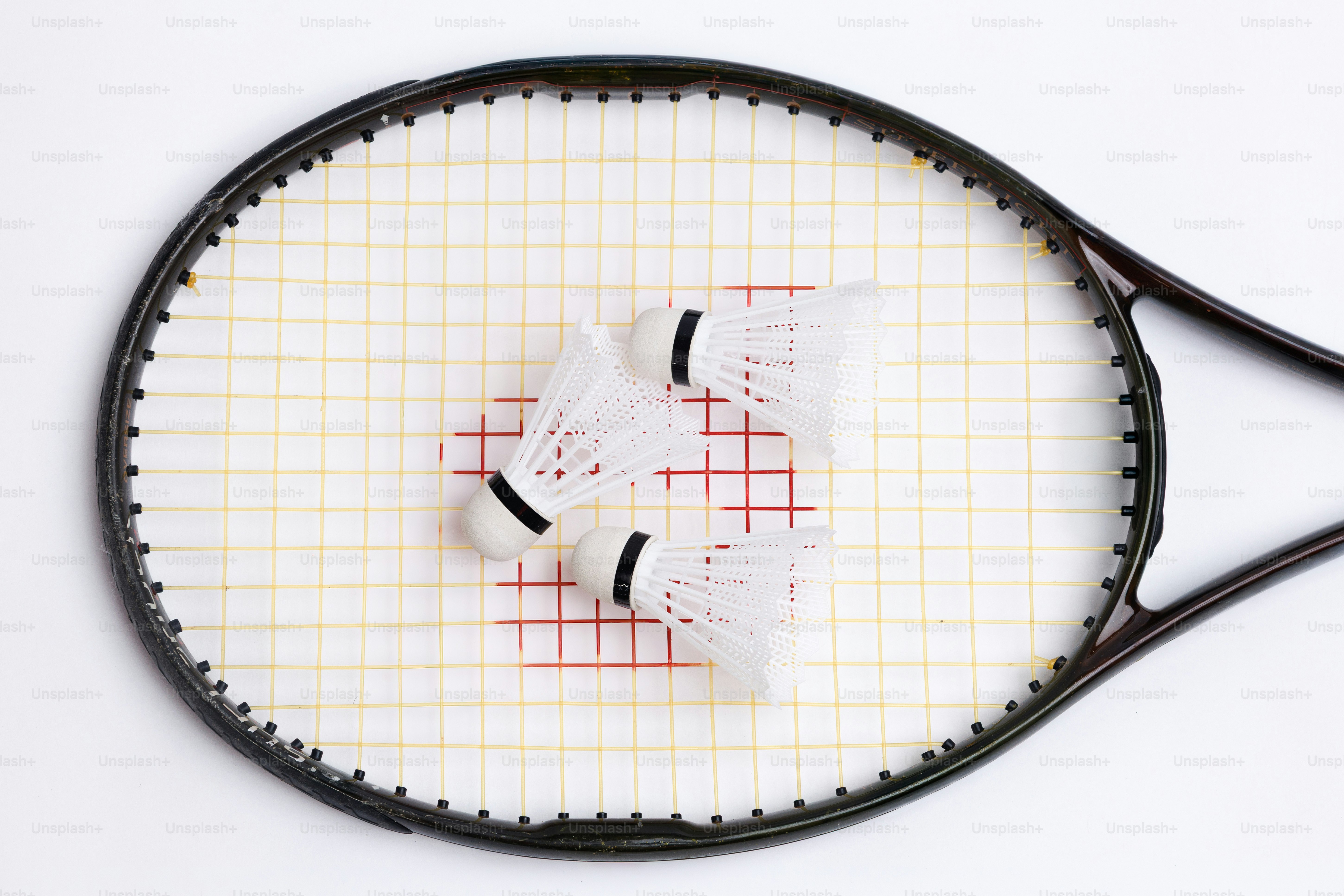 Three shuttlecocks resting on a tennis racket