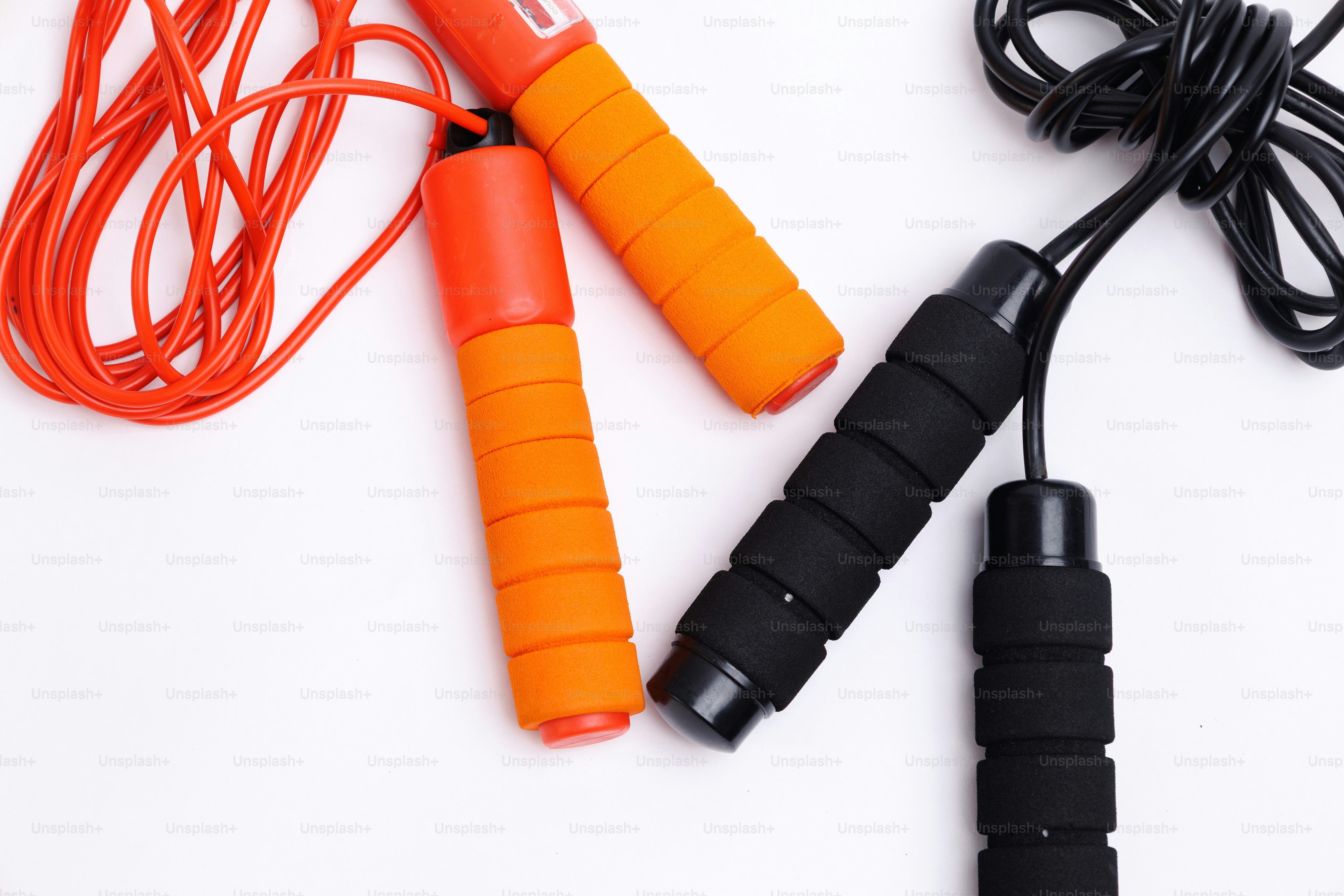 Two jump ropes with orange and black handles.