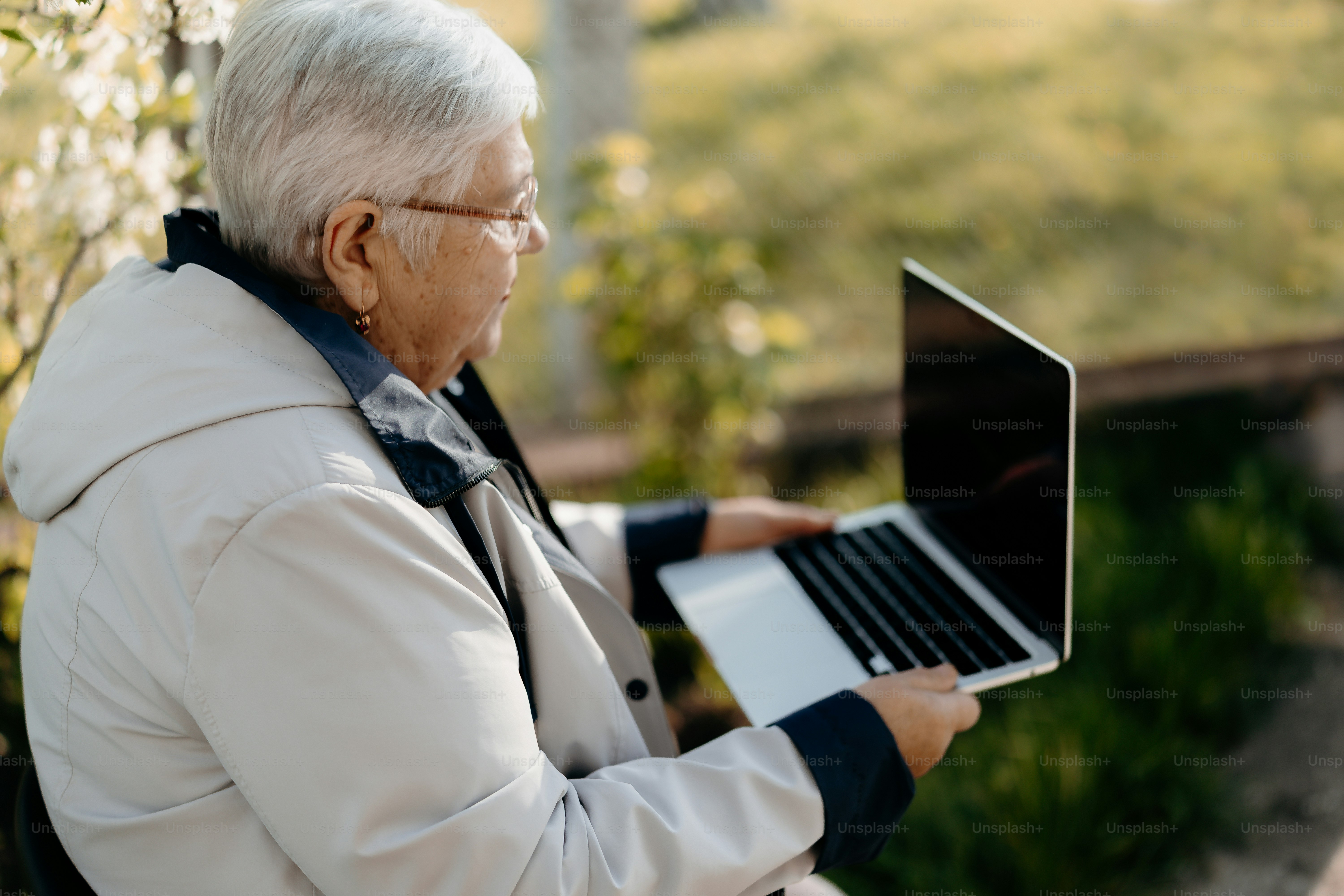 Ältere Frau benutzt einen Laptop im Freien