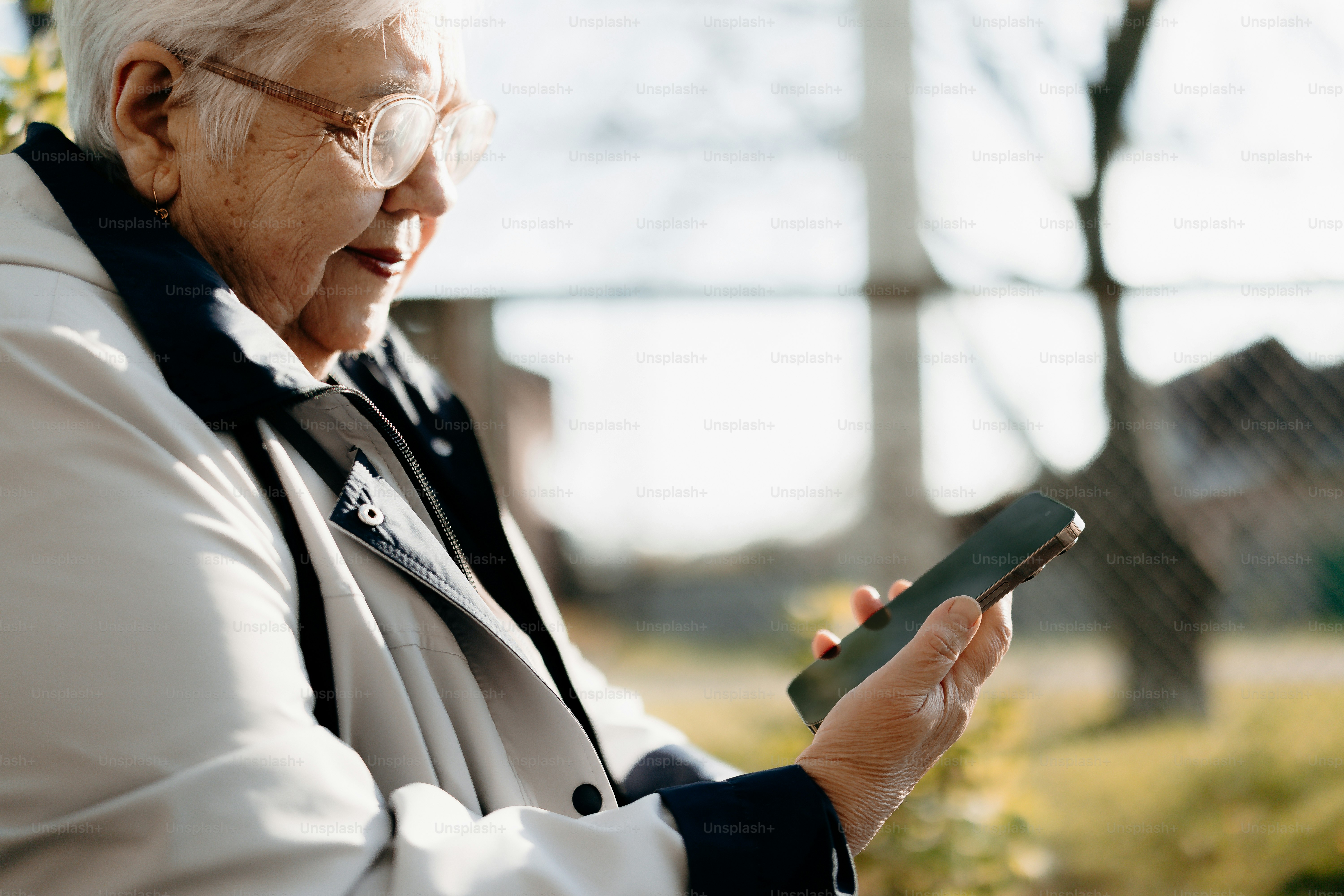 Ältere Frau benutzt ein Smartphone im Freien