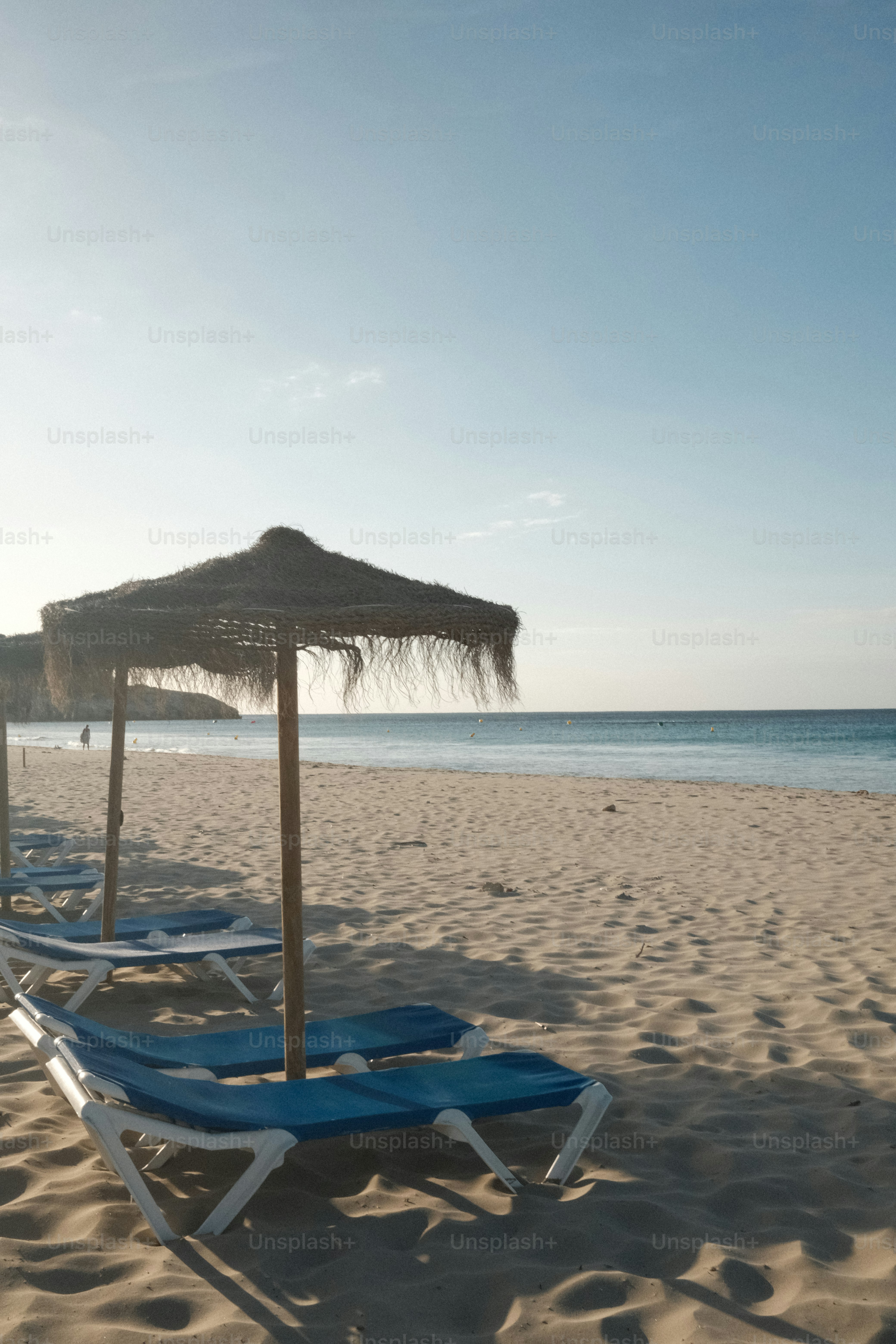 Sillas de playa y sombrilla en una playa de arena