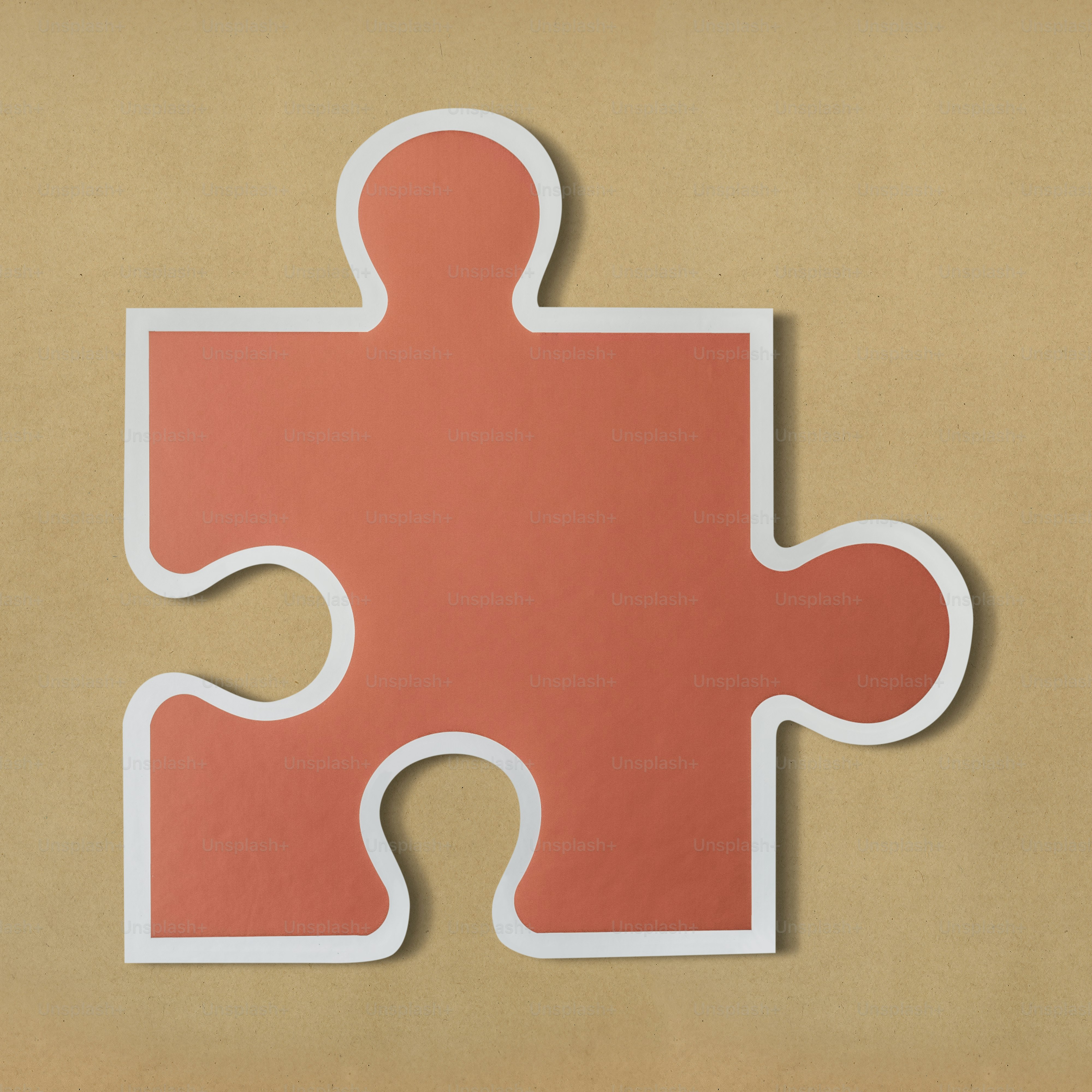 A single orange puzzle piece with a white border on a tan background