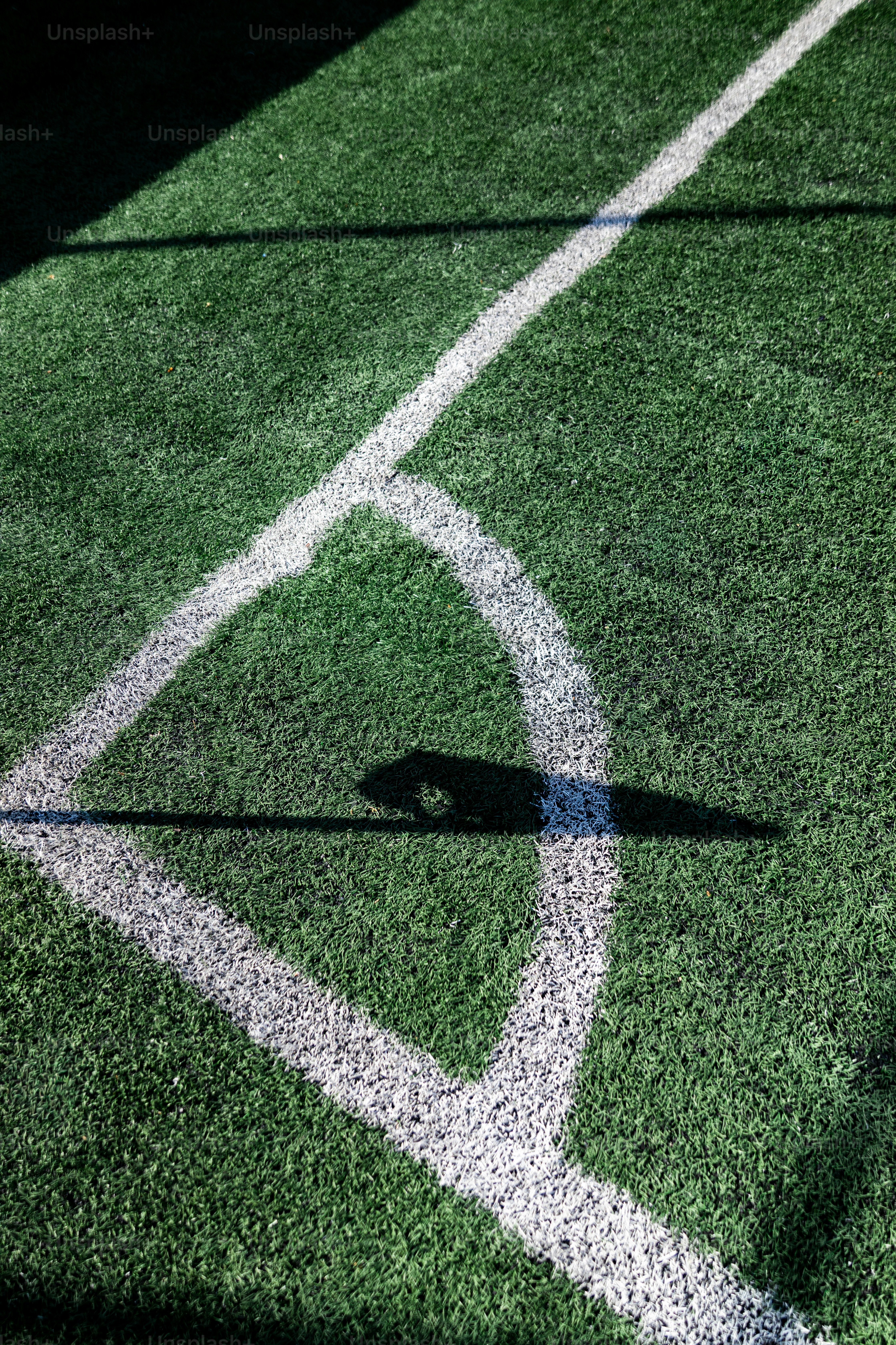 Ecke eines grünen Fußballfeldes mit weißen Linien