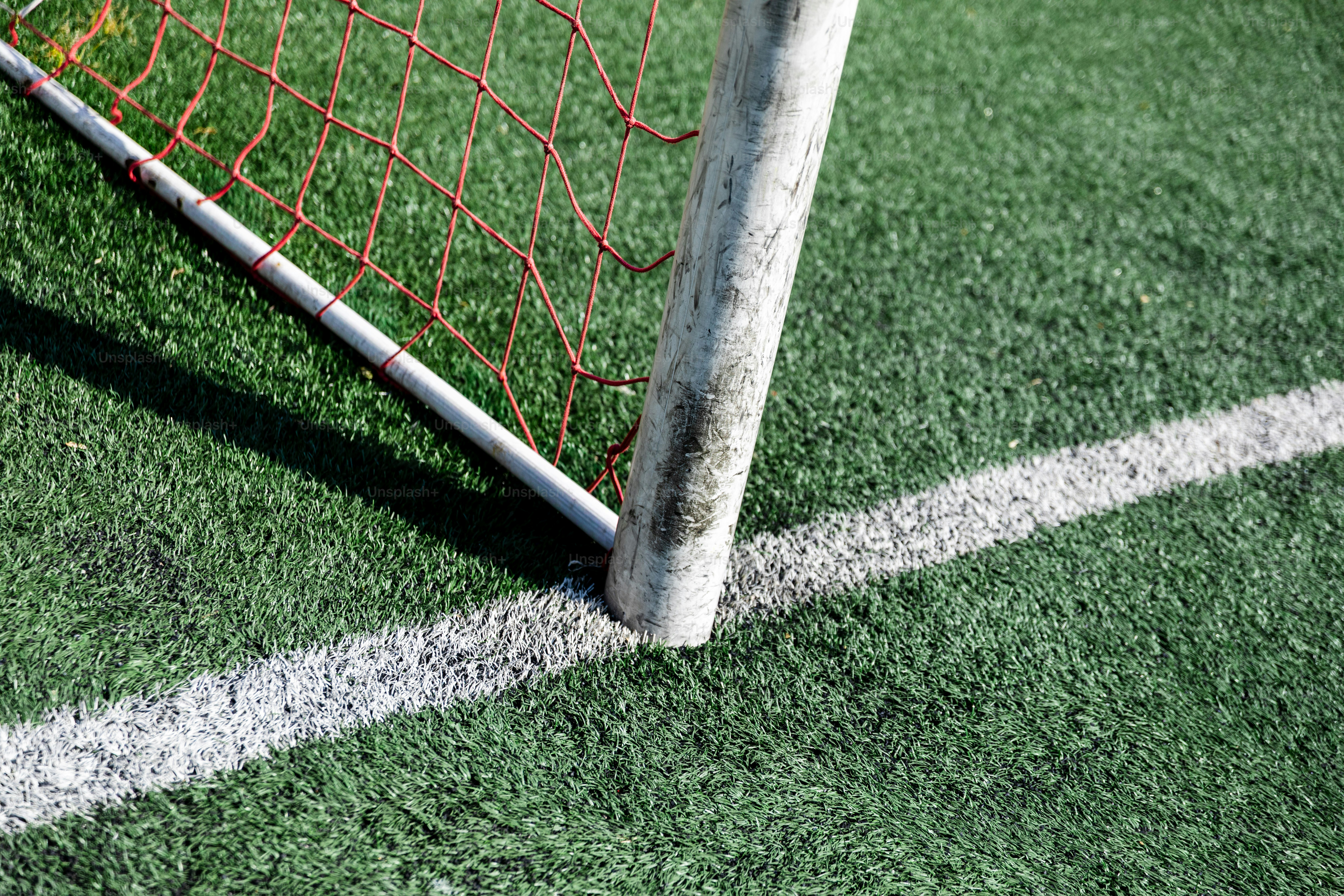 Nahaufnahme eines Fußballtorpfostens auf einem grünen Feld.
