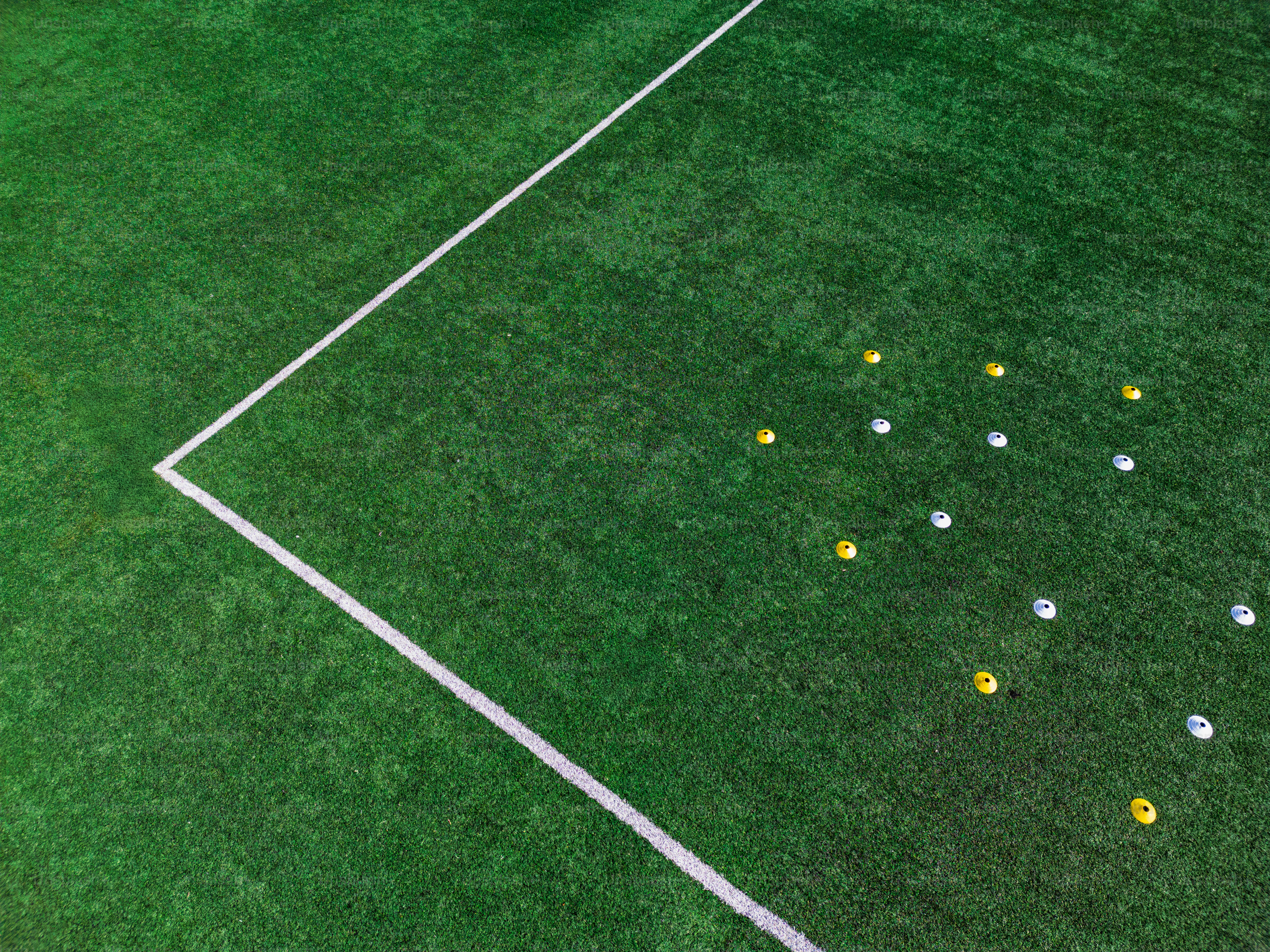 Kegel, die auf einem grünen Fußballfeld angeordnet sind