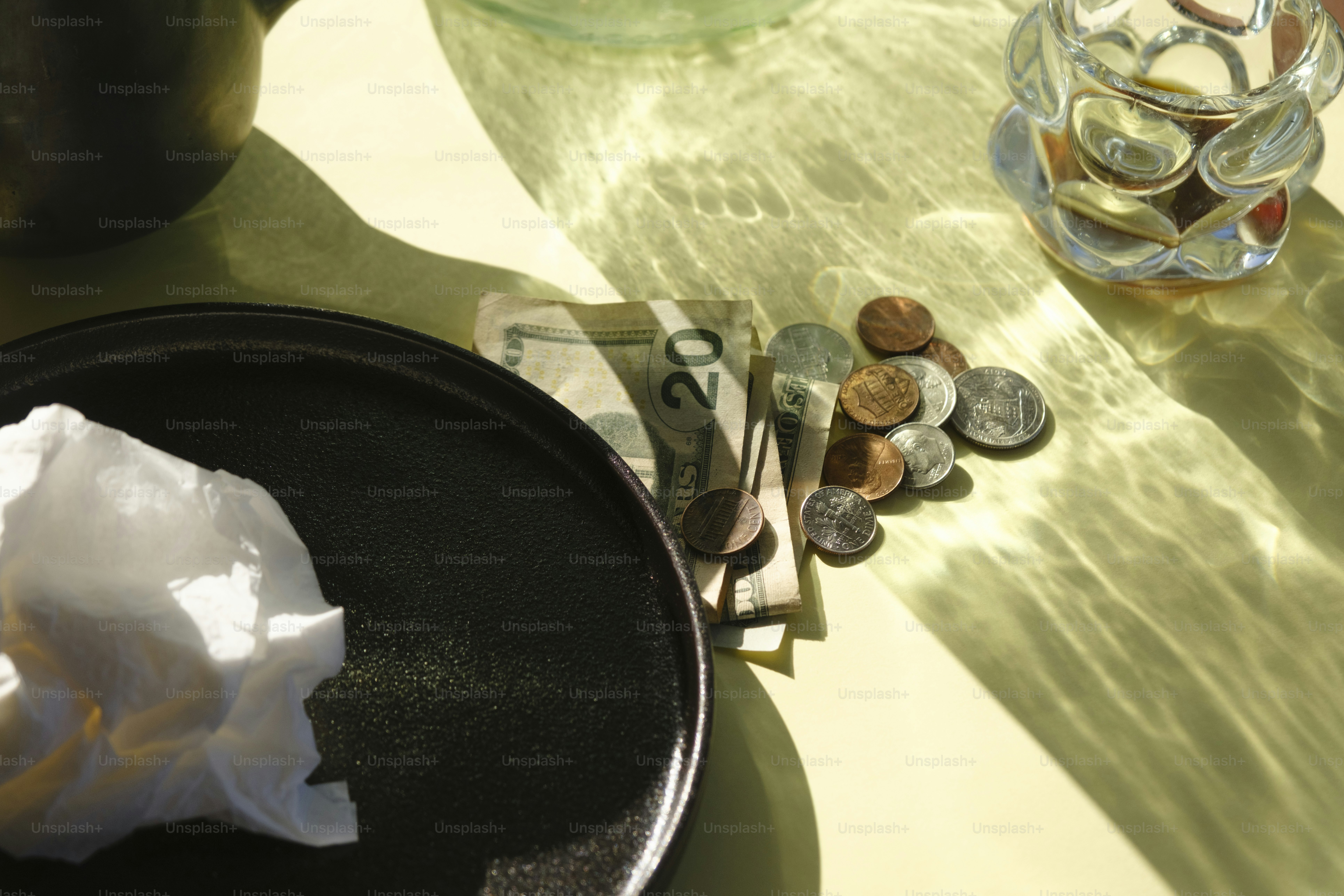Money and coins on a table with shadows.