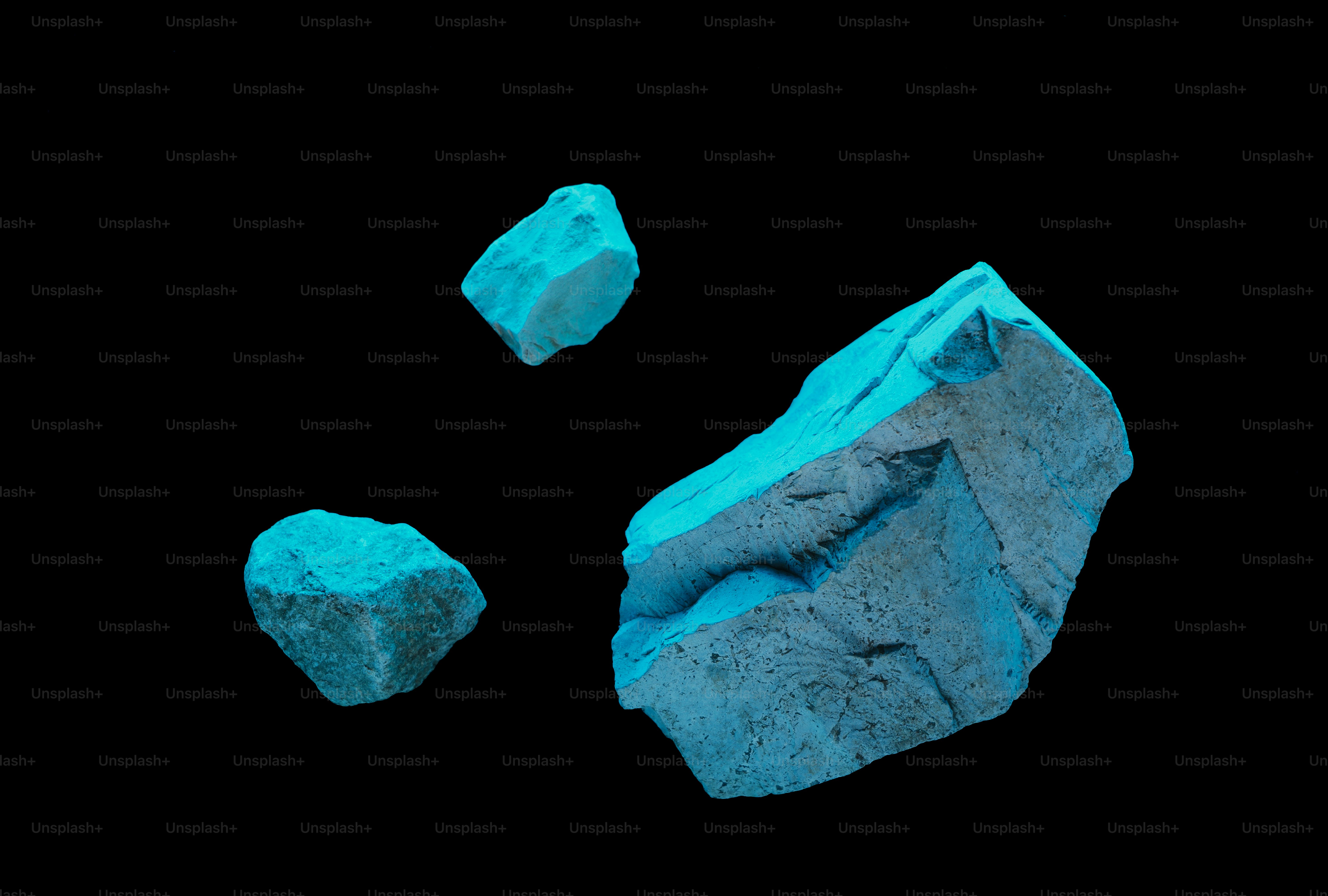 Three chunks of bright blue turquoise on black background
