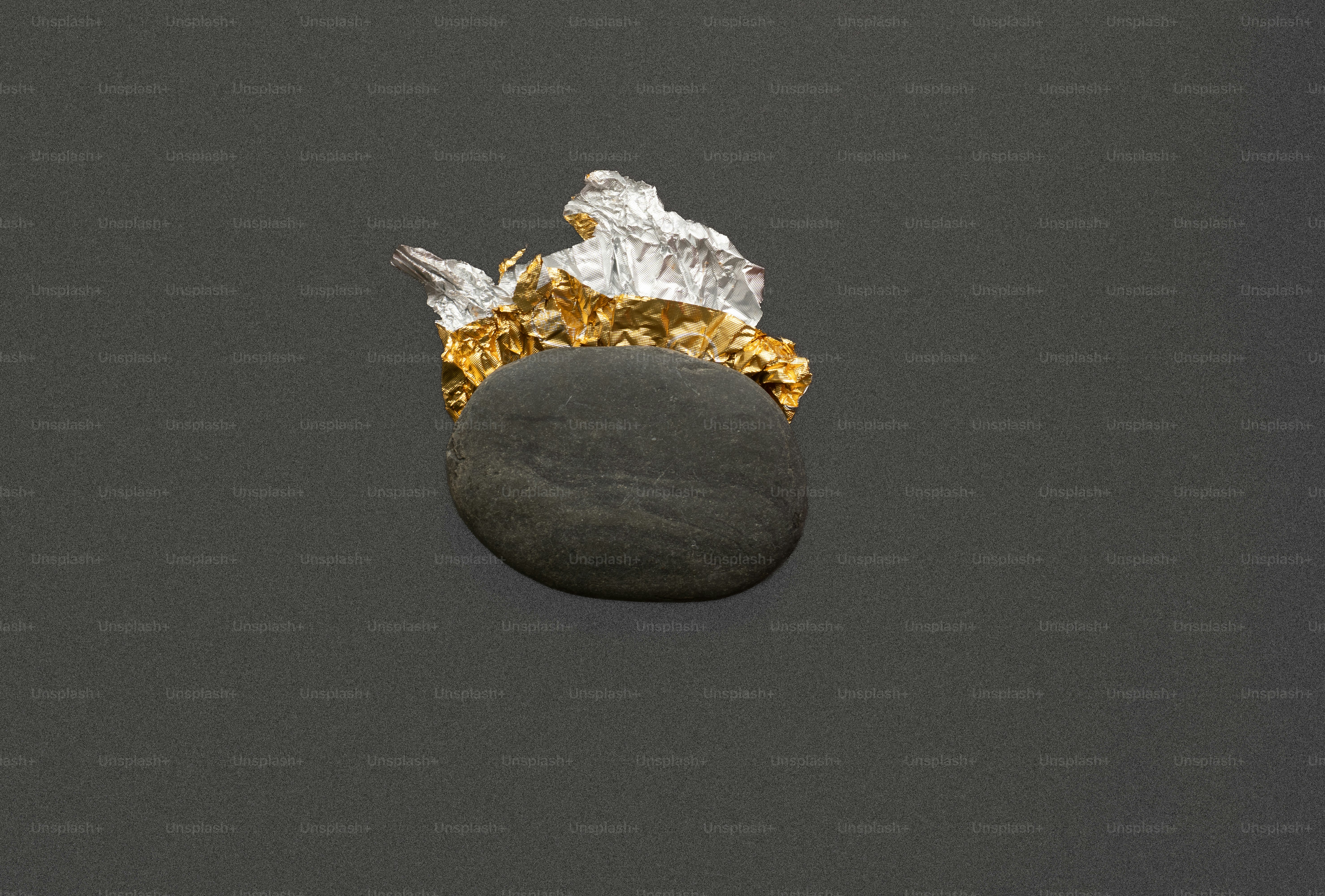 A dark stone with gold and silver leaf accents