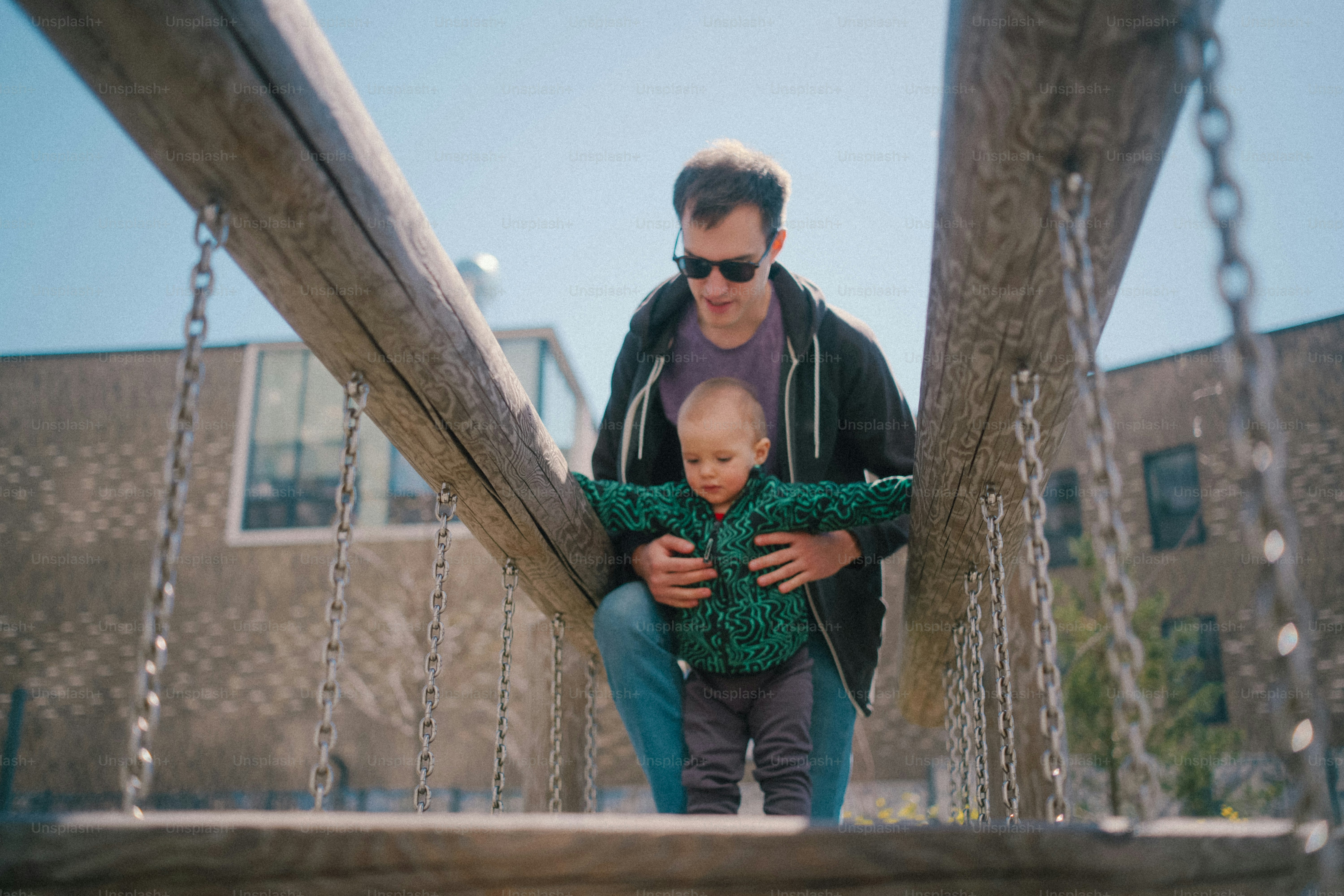 Un uomo aiuta il bambino a camminare su un ponte di legno