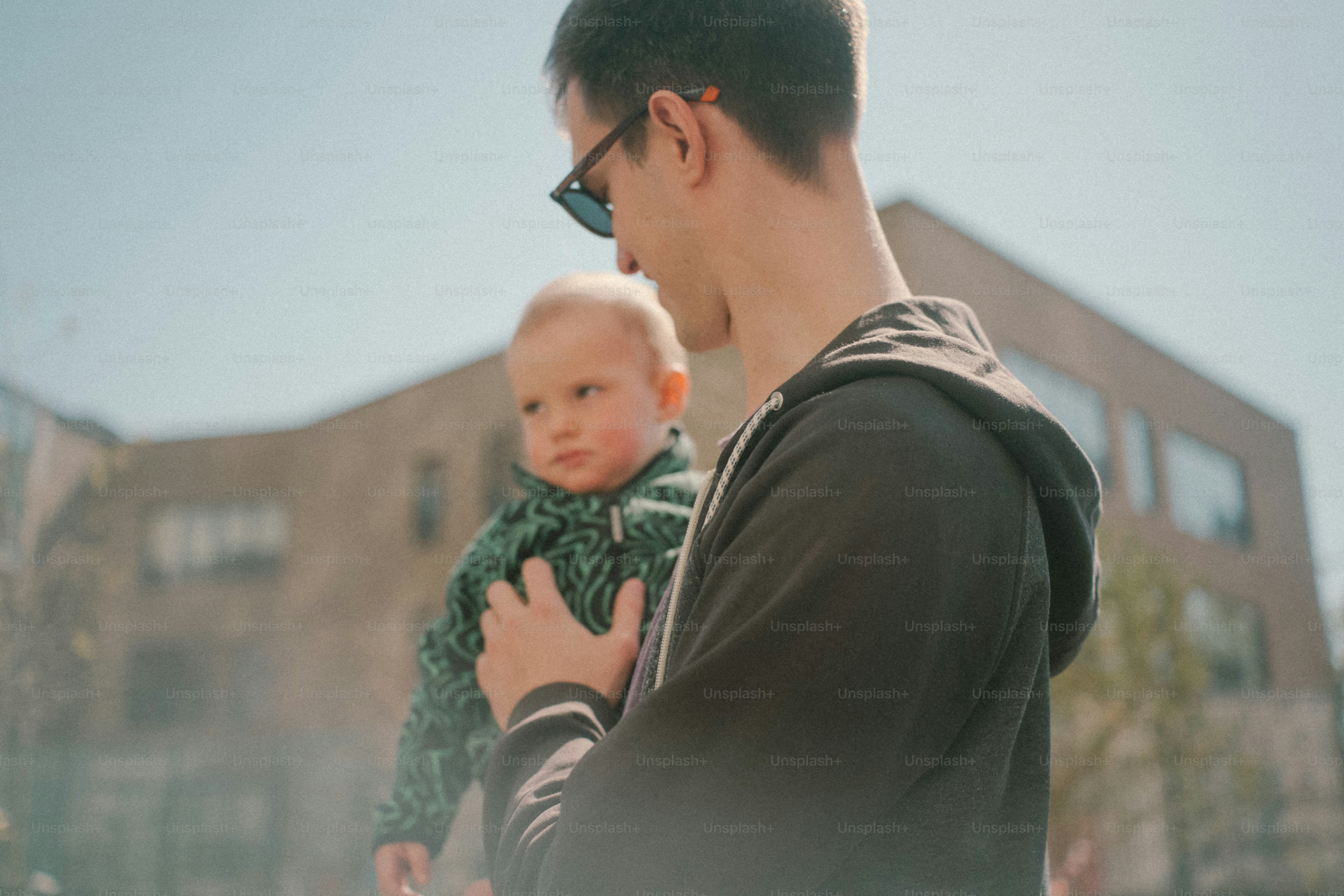 Uomo che tiene un bambino all'aperto con uno sfondo di edificio