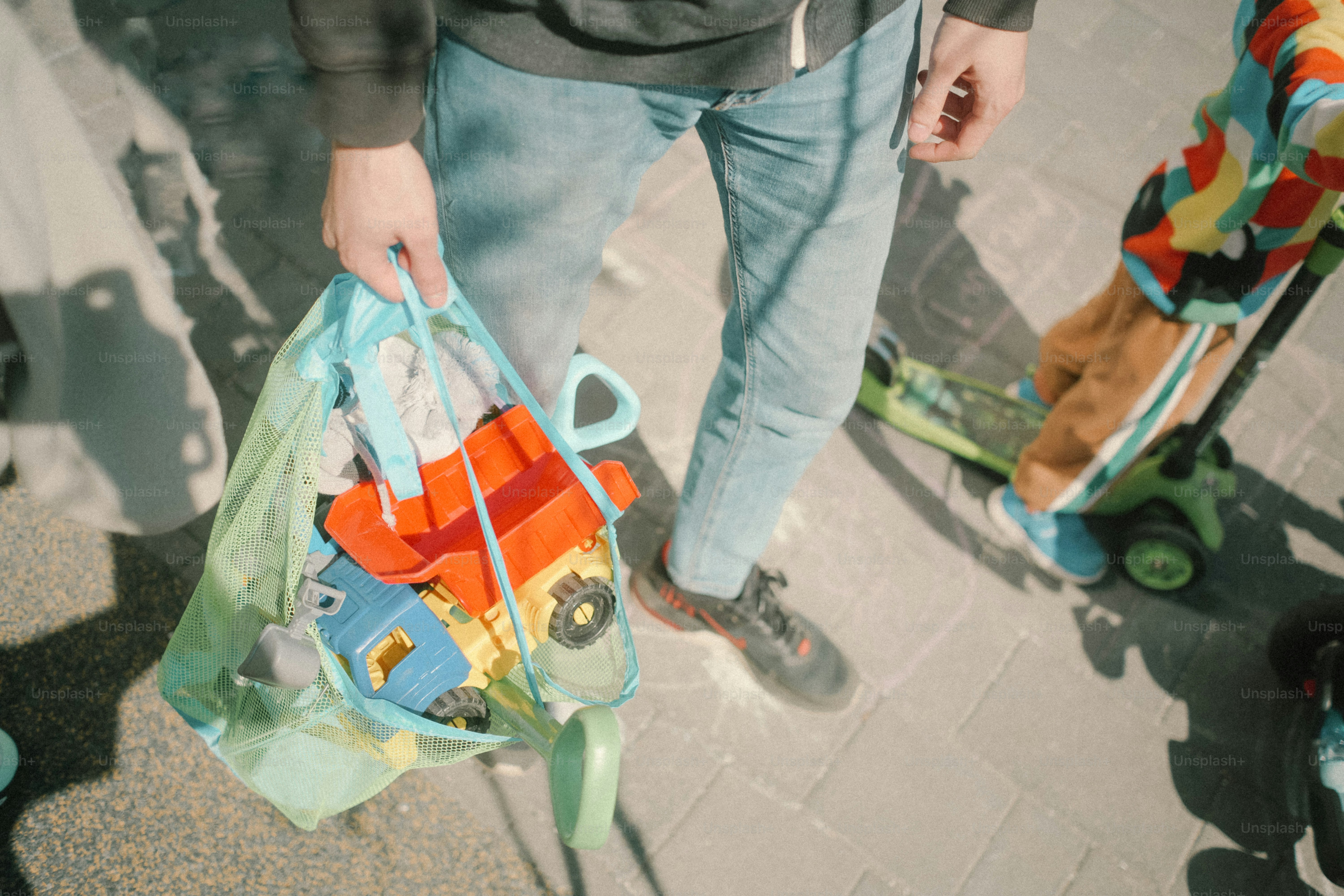 Persona che tiene una borsa di giocattoli vicino a uno scooter.