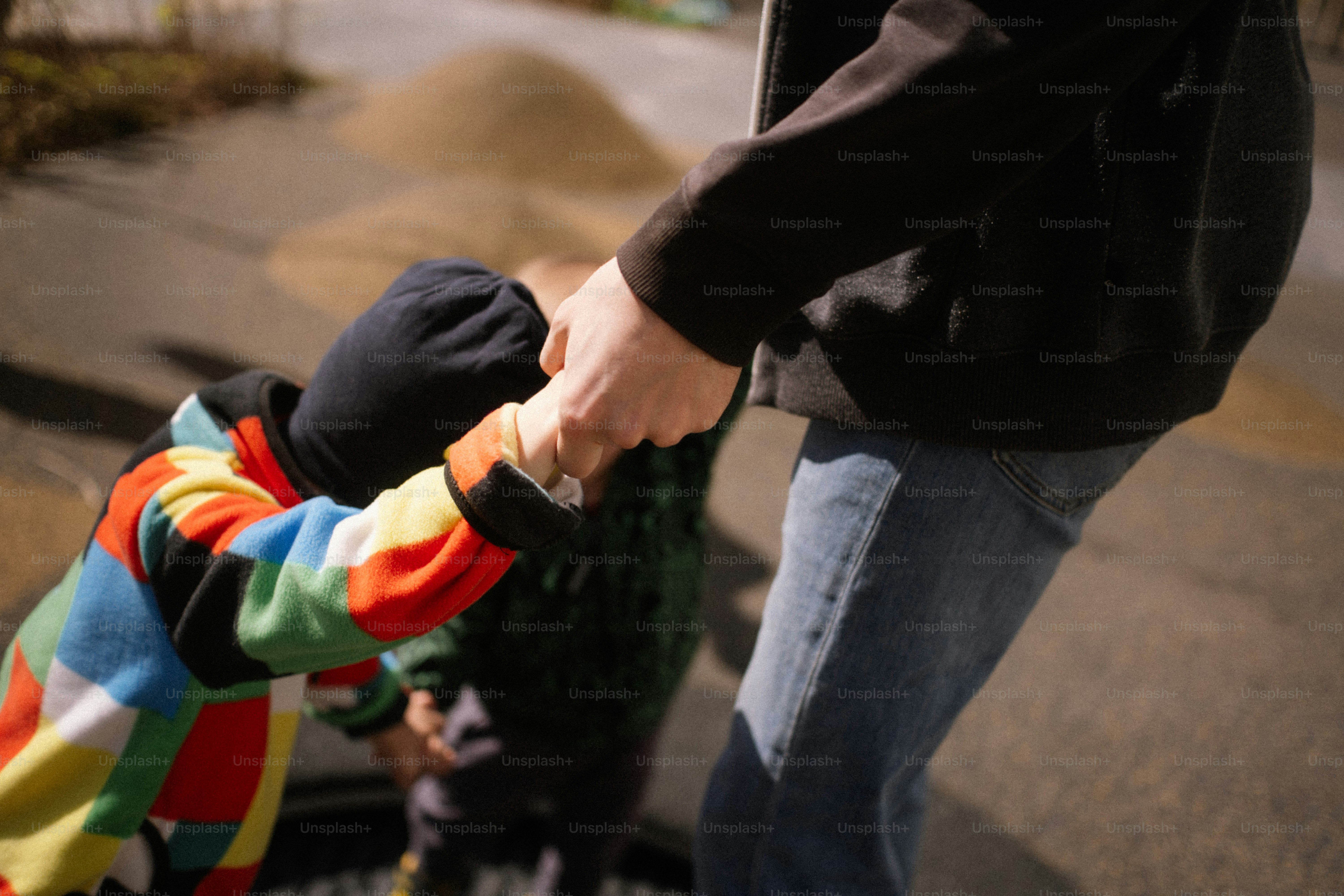 Adulto che tiene la mano di un bambino all'aperto