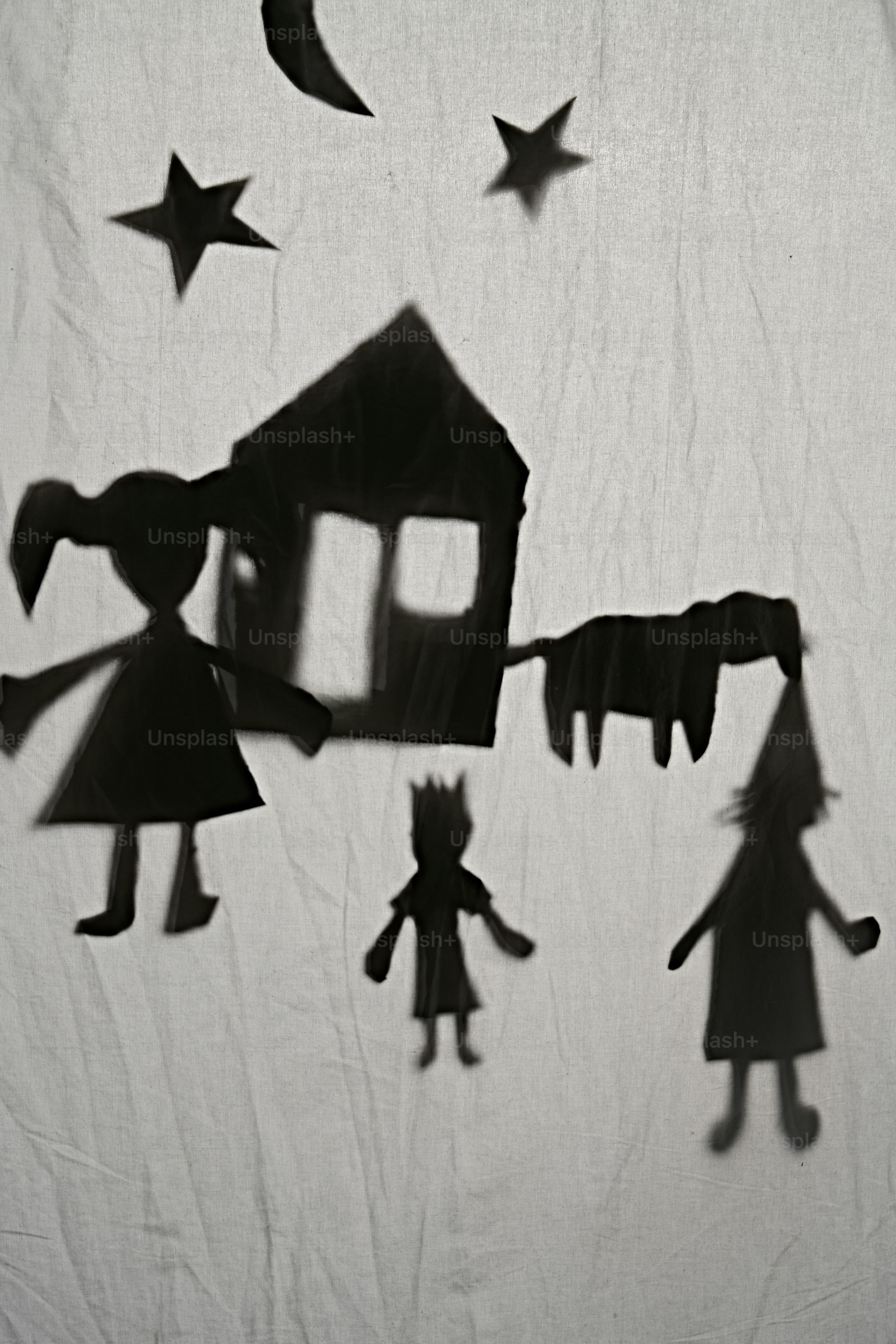 Shadow puppets of a family and house at night