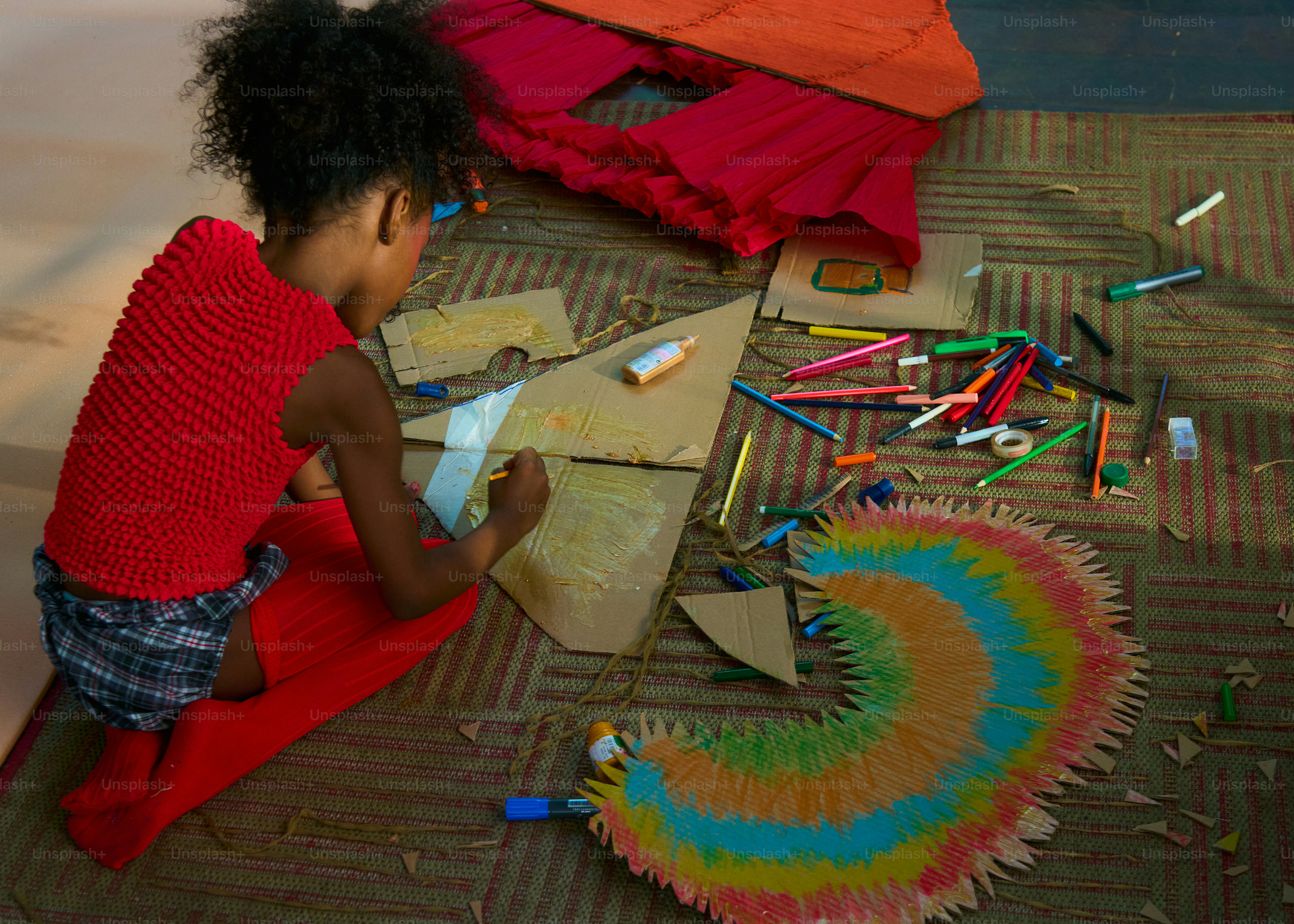 Child drawing on cardboard with colorful markers