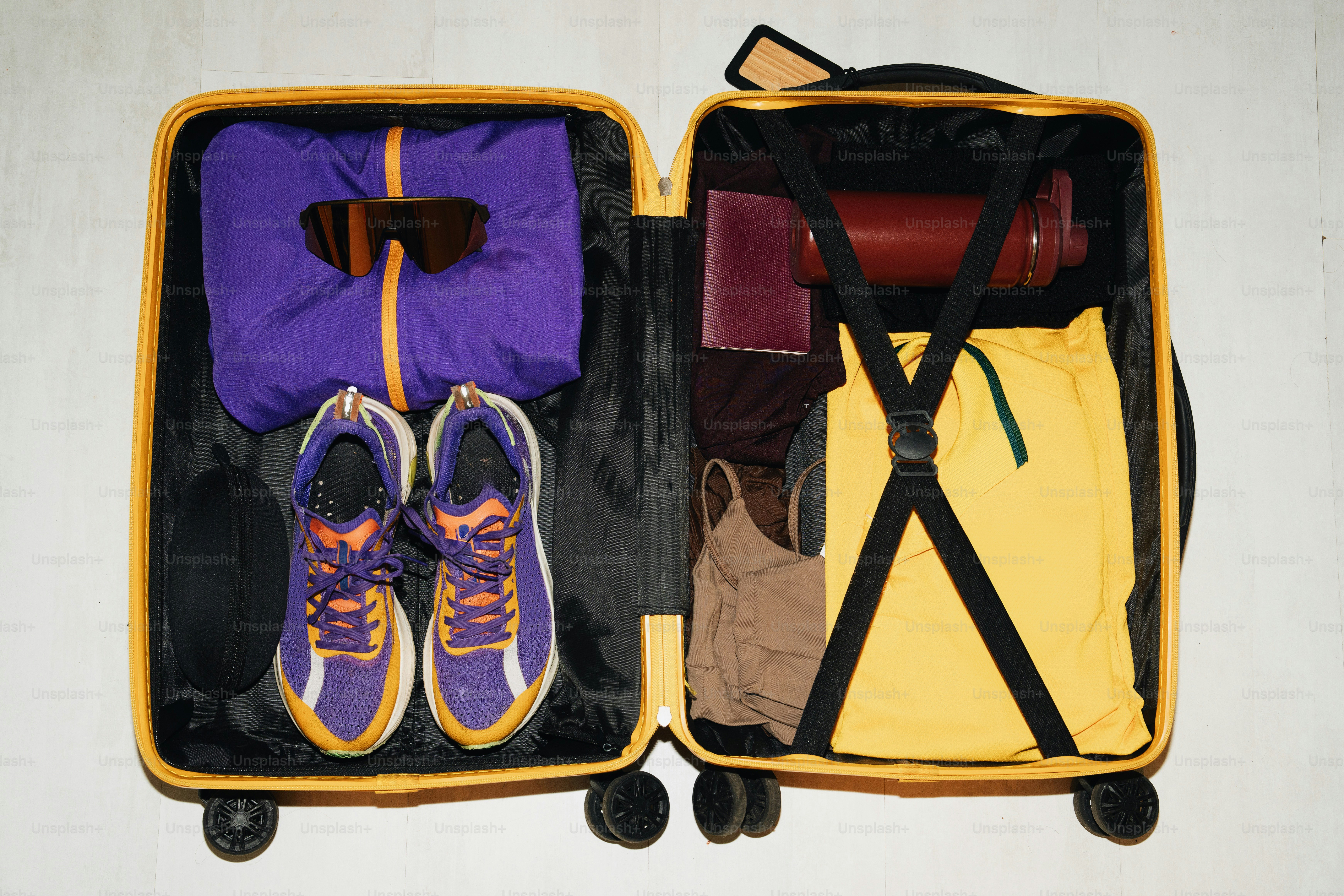 Open suitcase packed with clothes and shoes for travel.