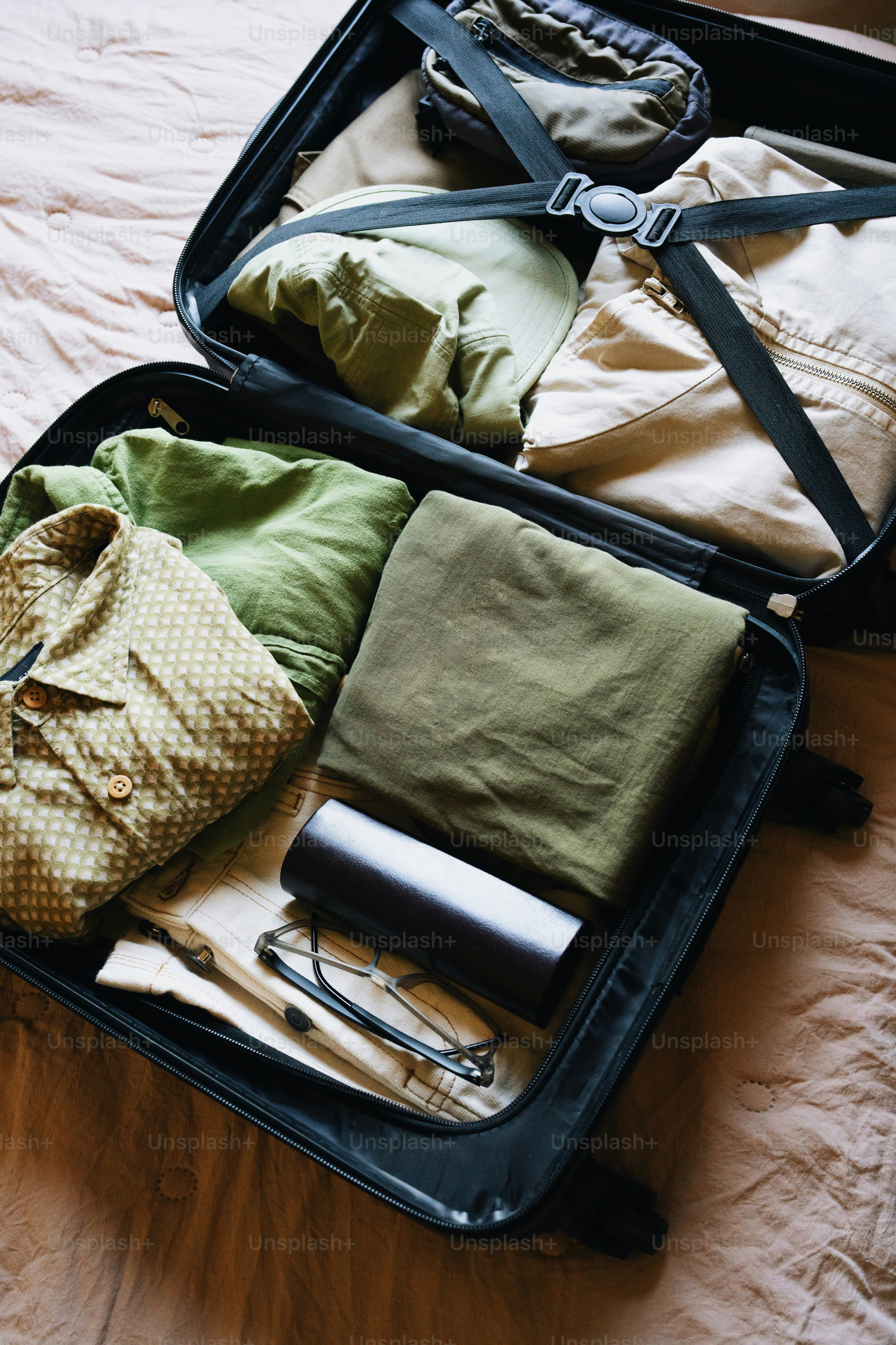 Clothes and accessories packed neatly in an open suitcase.