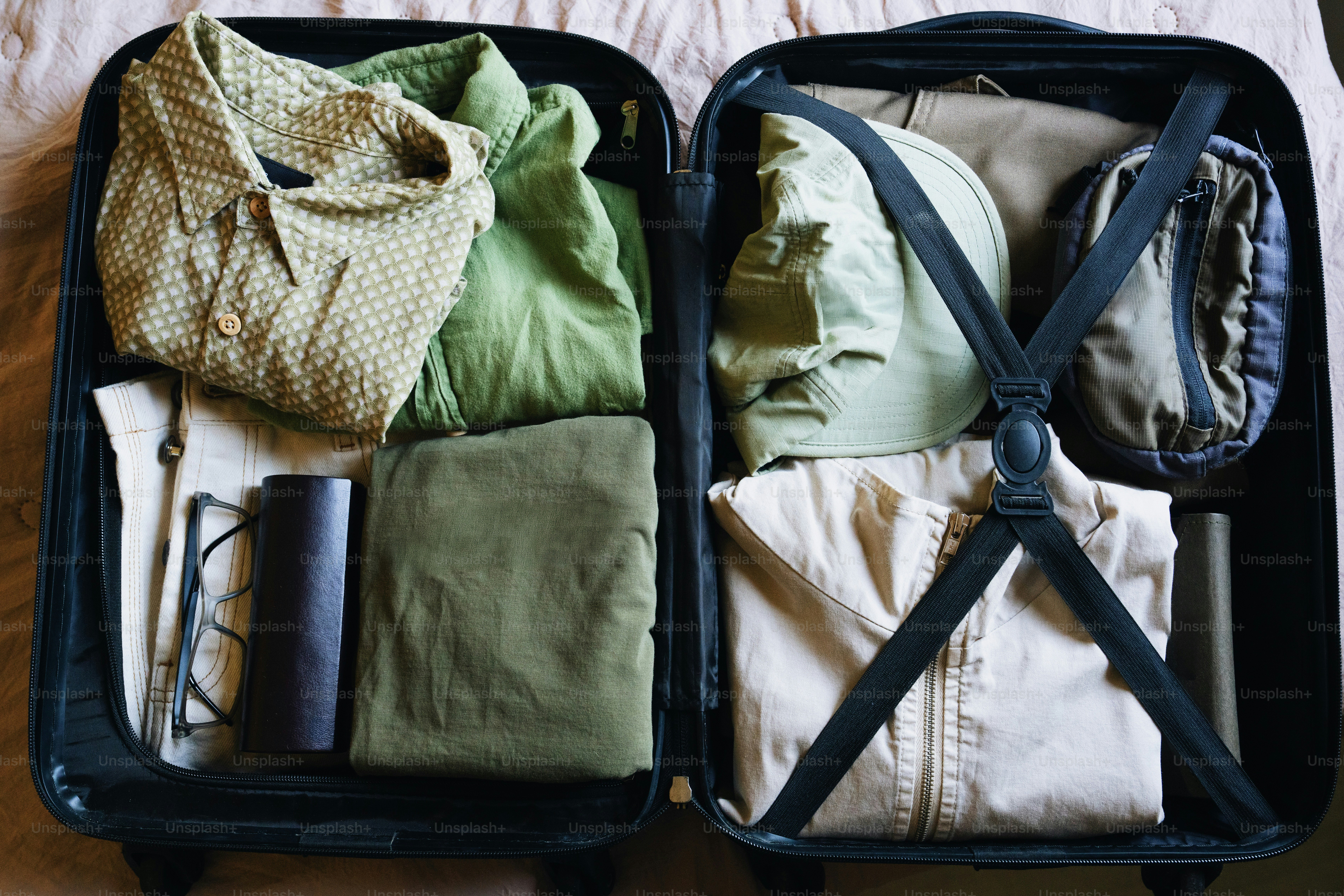 Open suitcase packed with clothes and accessories.