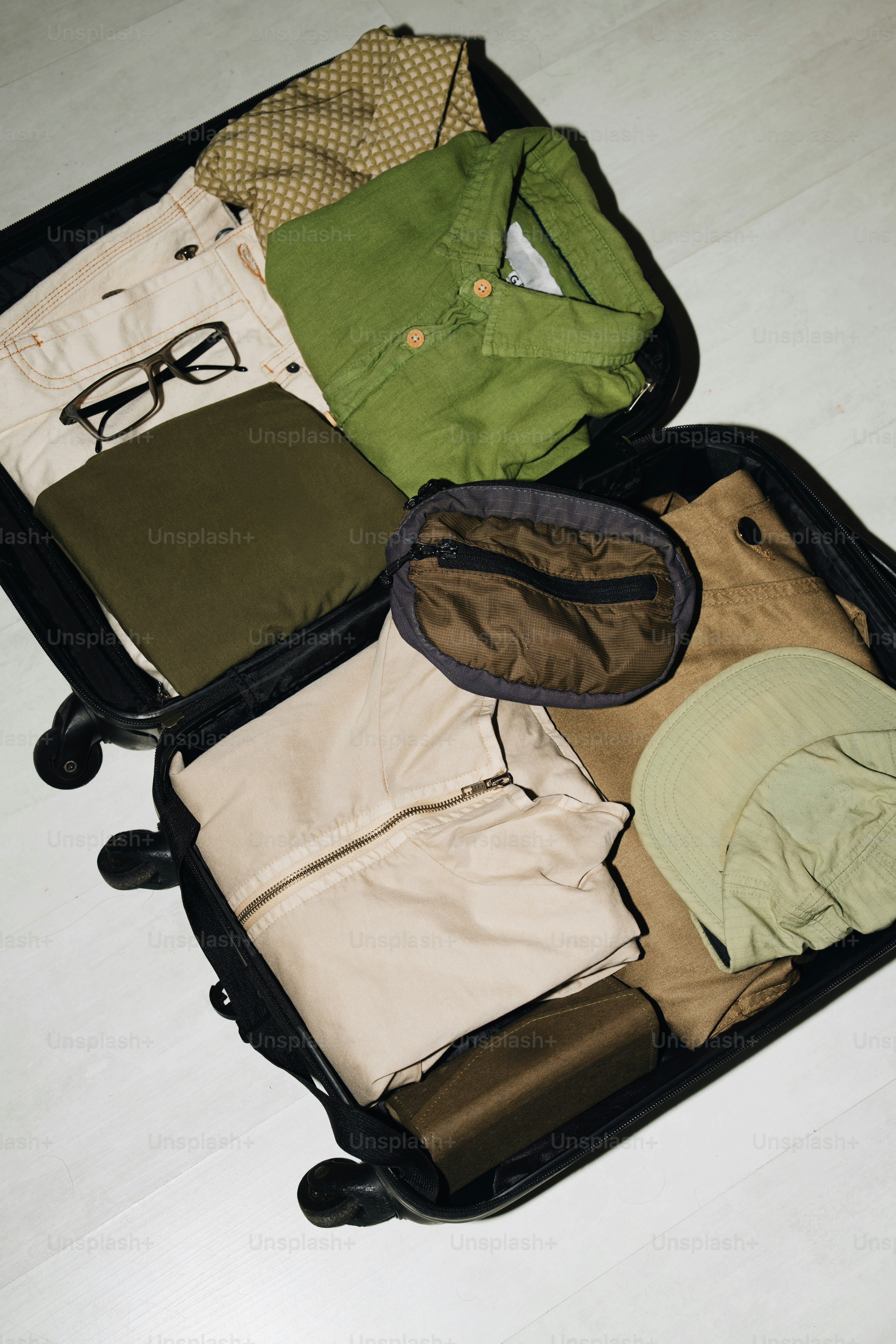 Open suitcase packed with clothes and accessories.