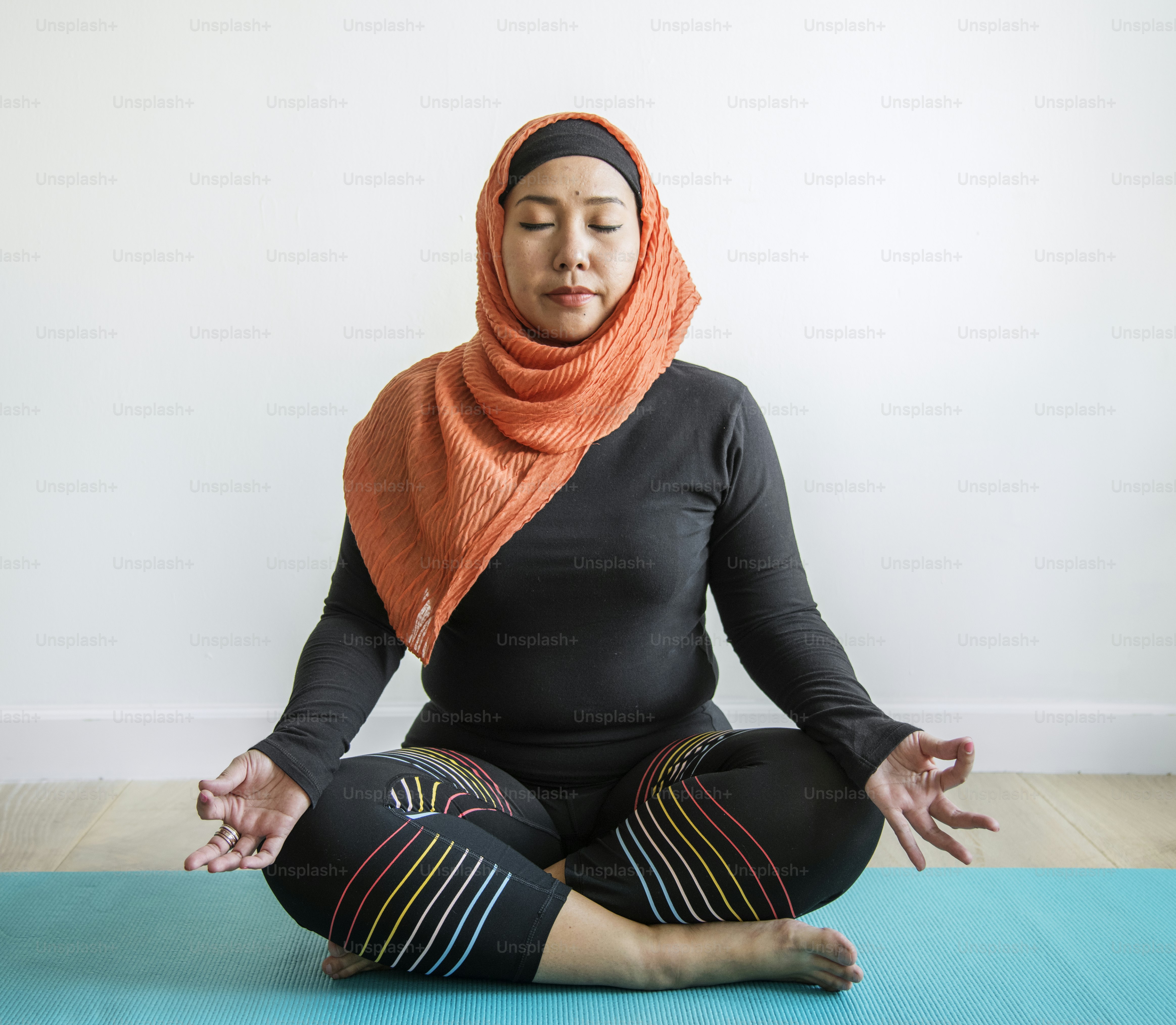 Wanita Islam melakukan yoga di kamar