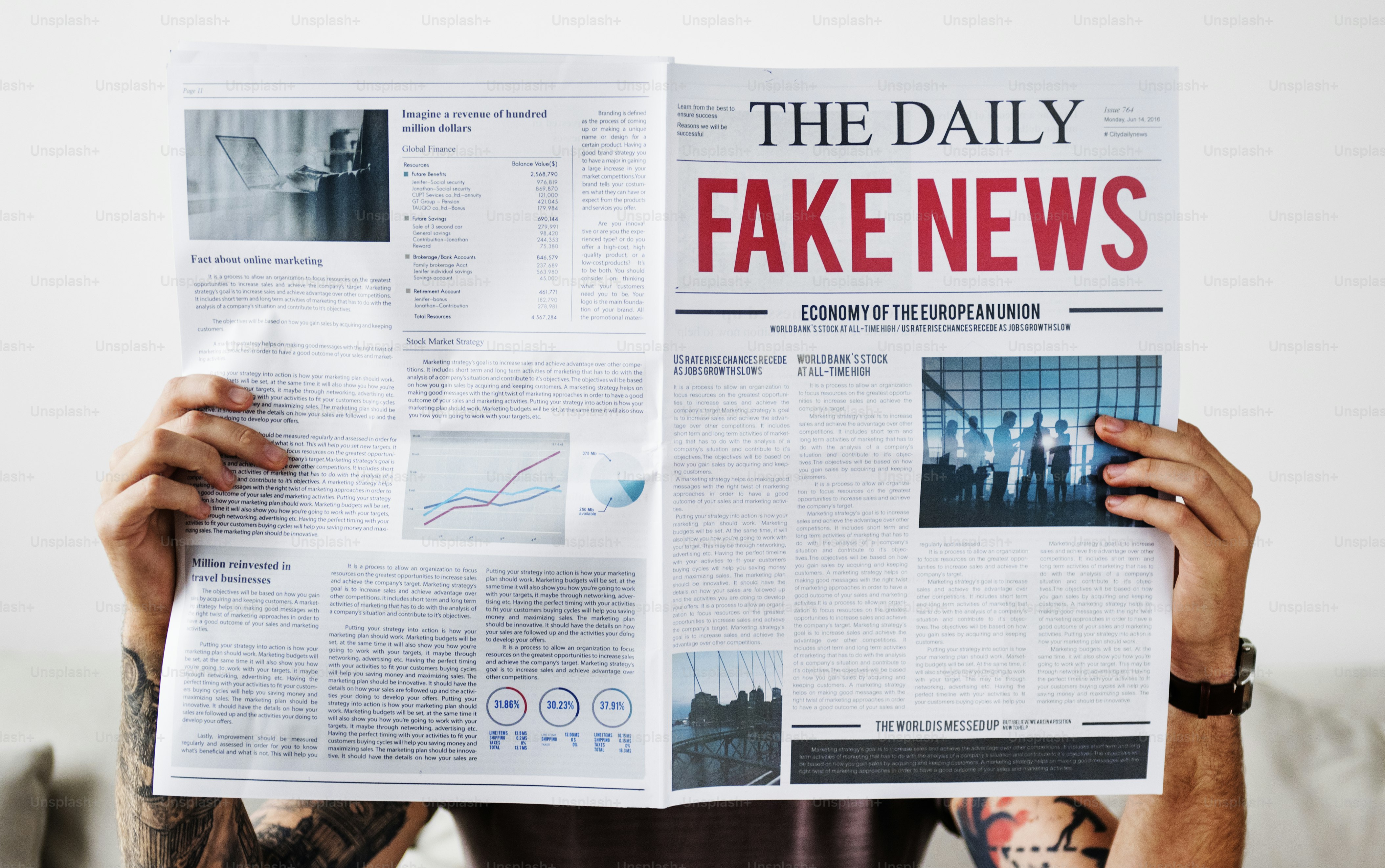 A person holding a newspaper with the headline FAKE NEWS in large red letters