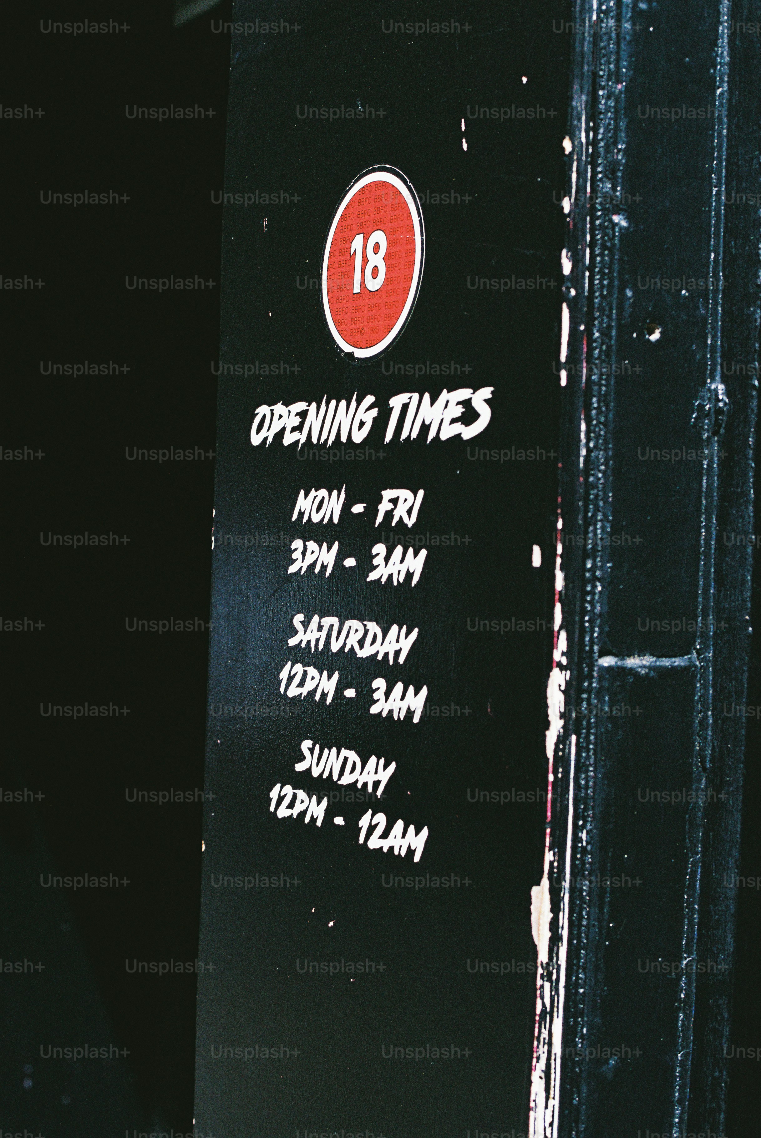 Opening times sign with 18 rating.