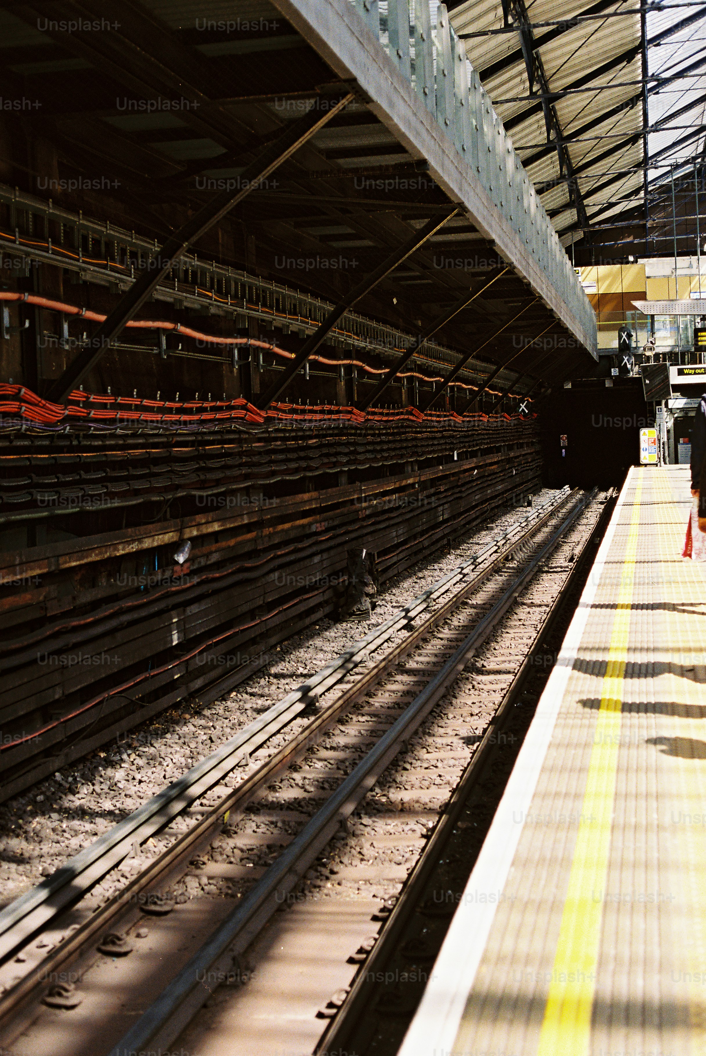 Train tracks leading into a dark tunnel at a station. photo – Travel ...