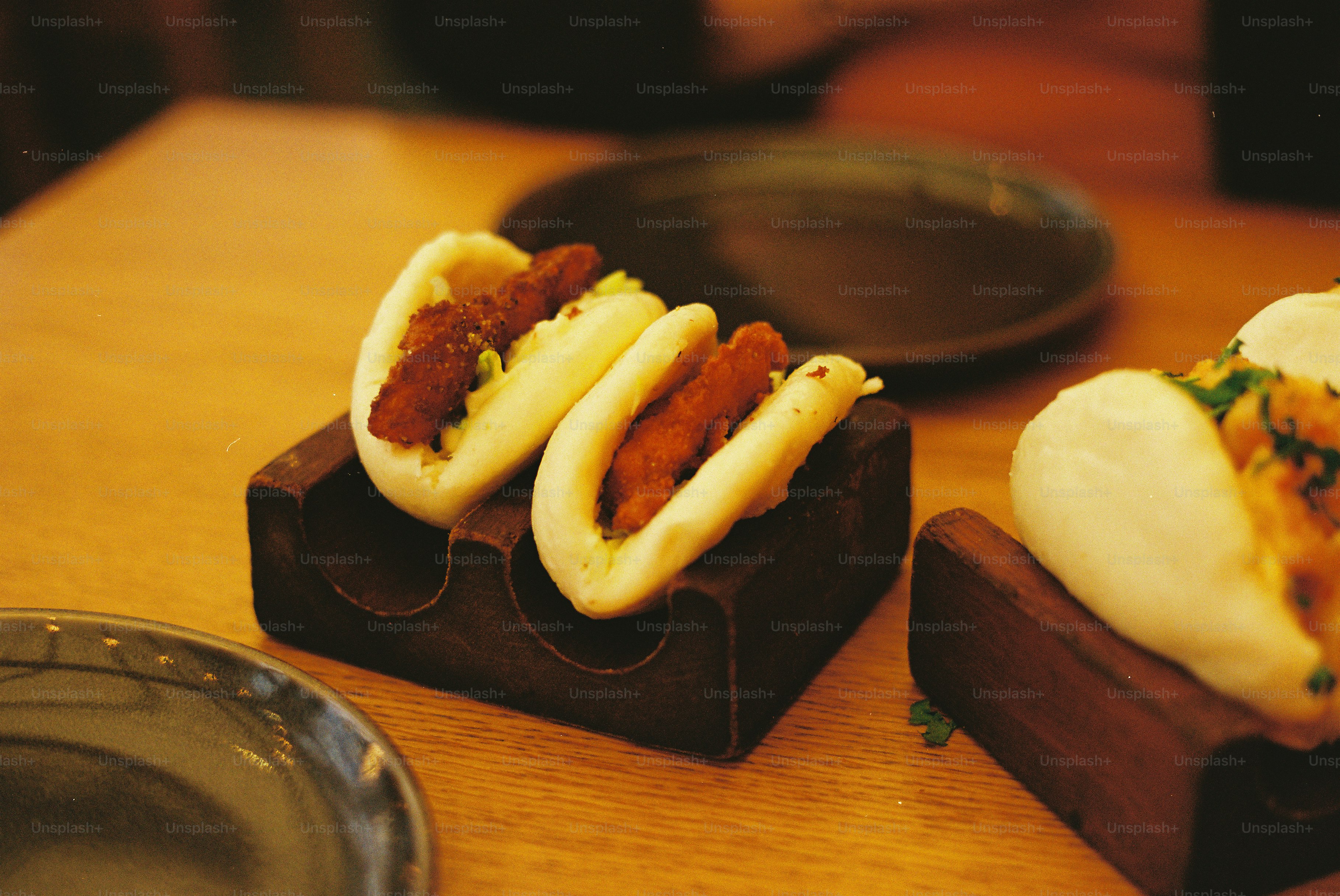 Two steamed buns filled with fried chicken