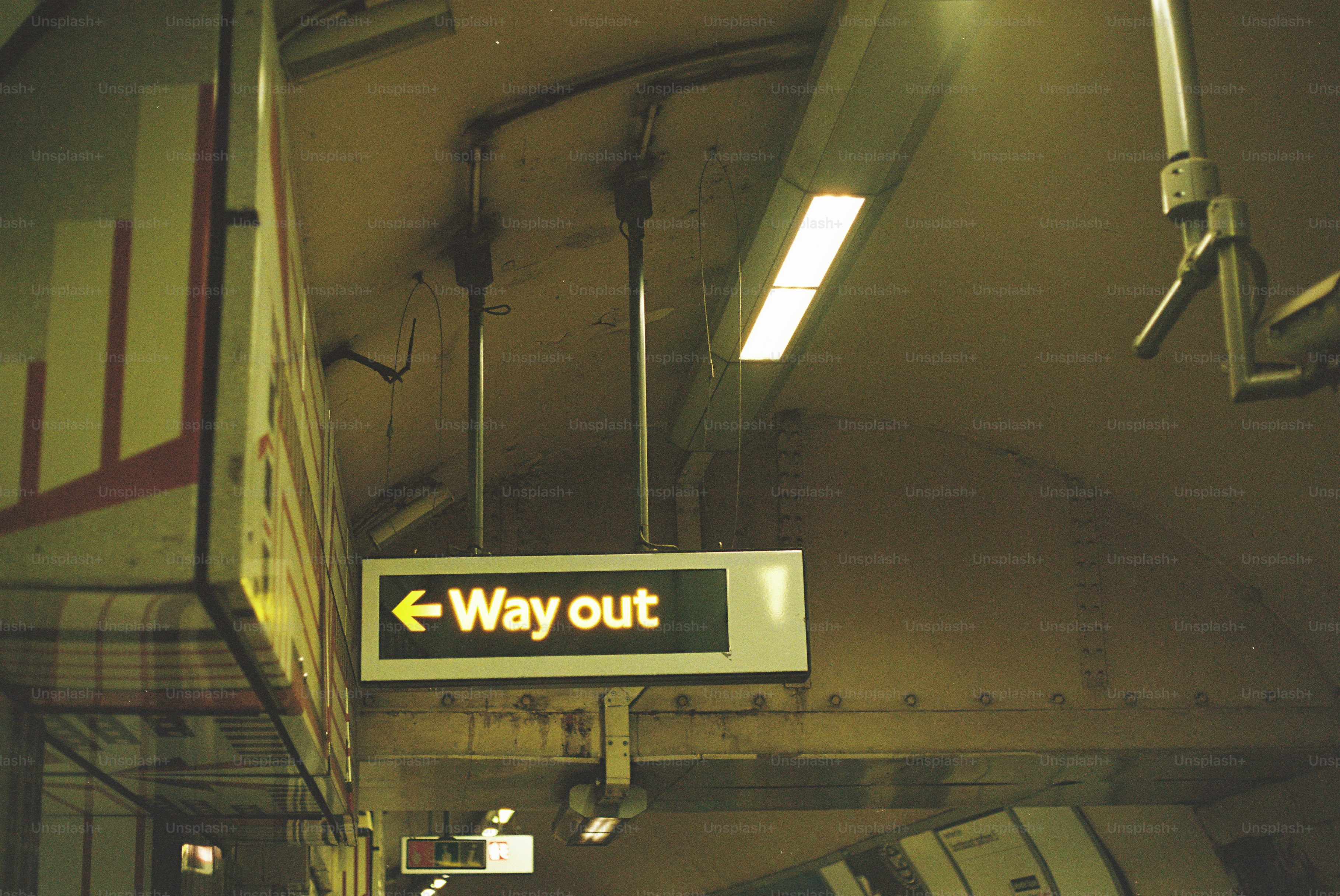 A glowing way out sign in a subway station.