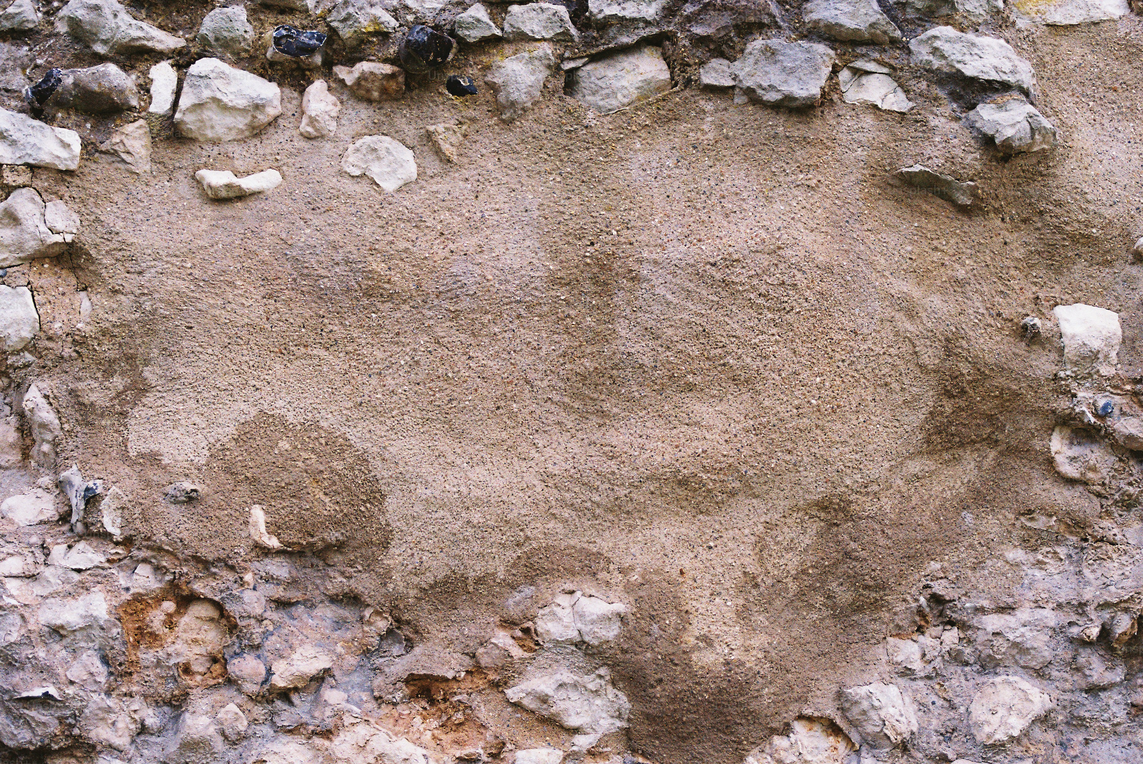 Rough textured plaster patch on stone wall
