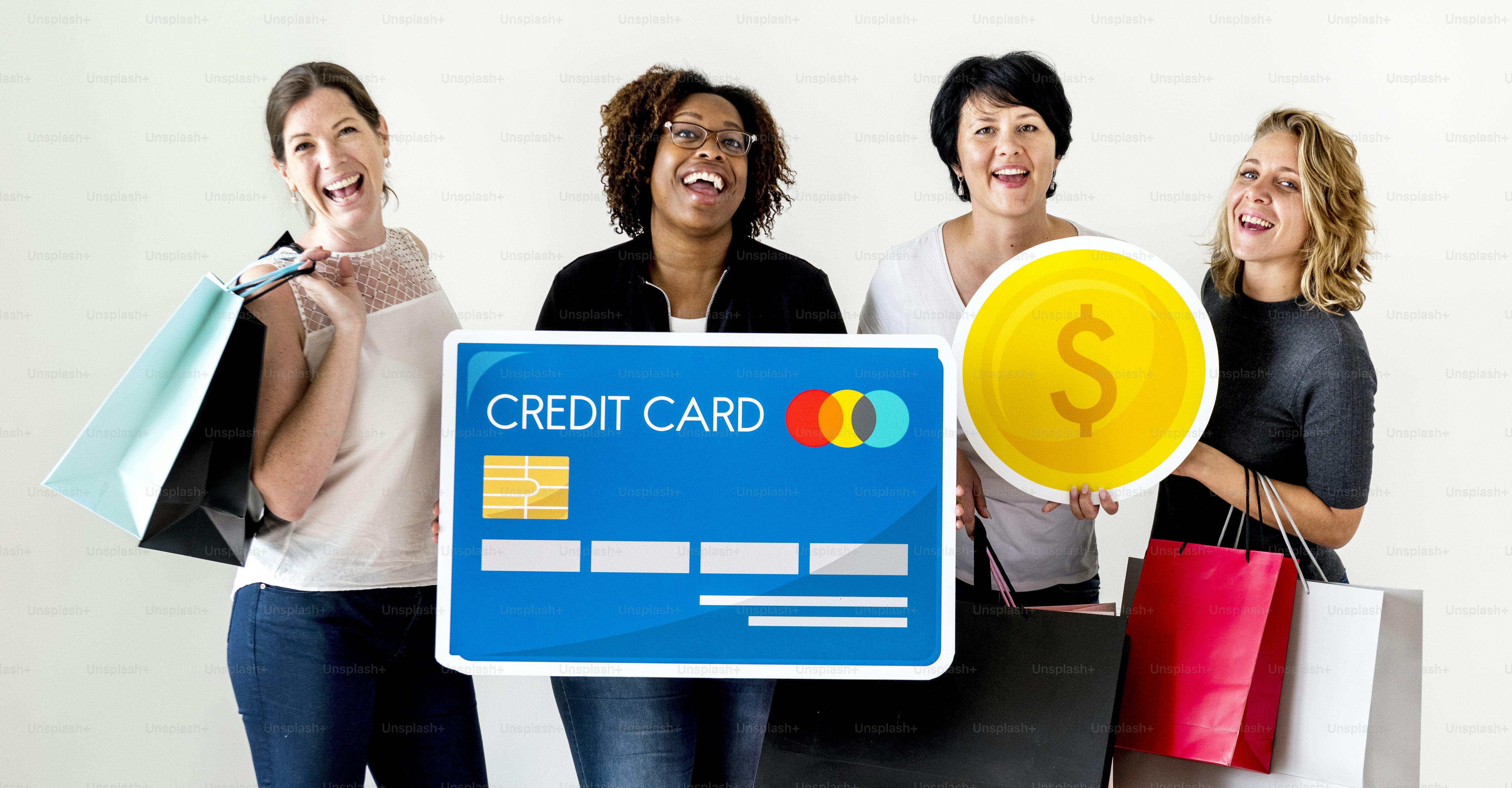 Four women holding shopping bags and a large credit card sign