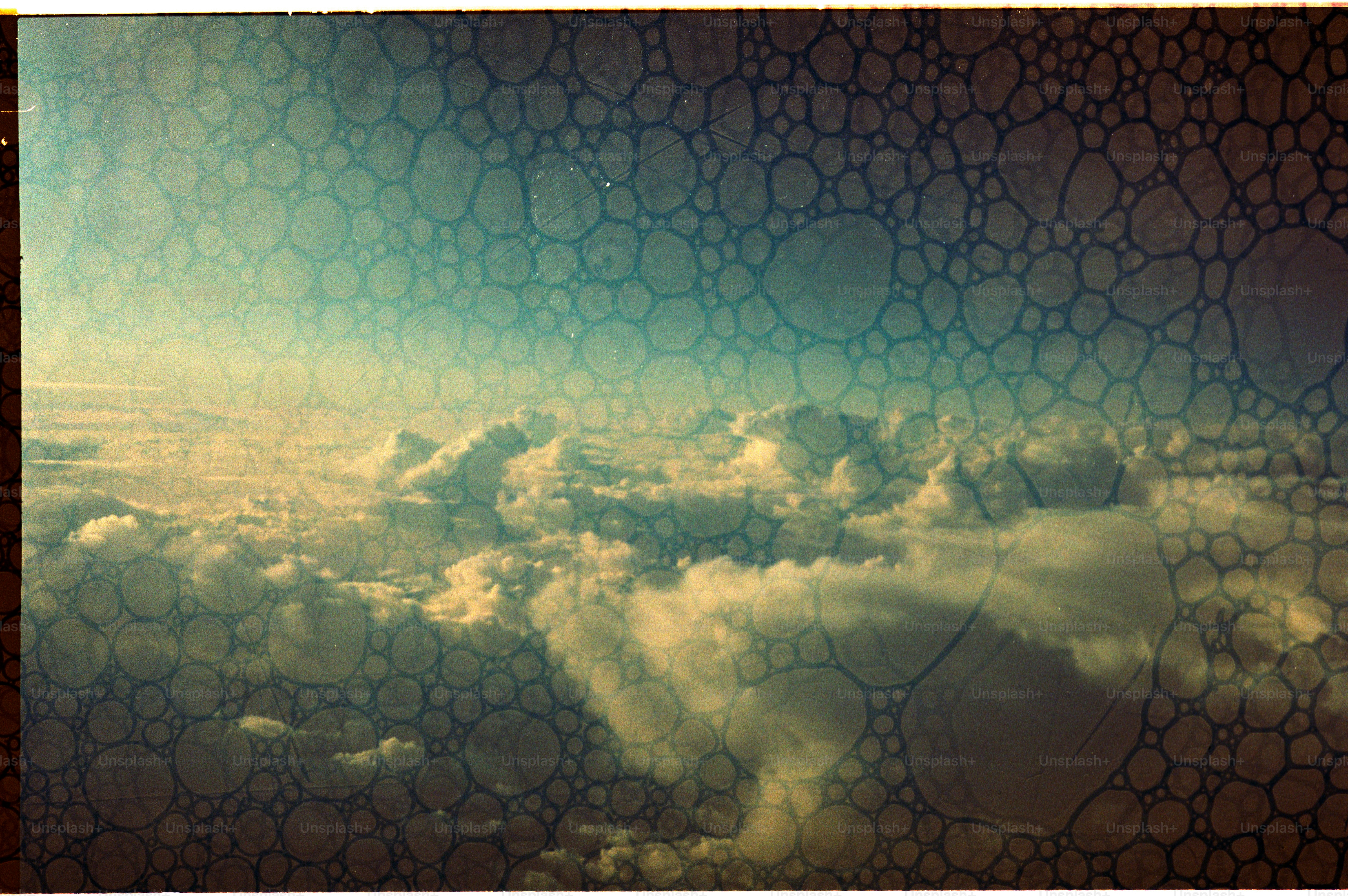 Clouds seen from an airplane window with water droplets.