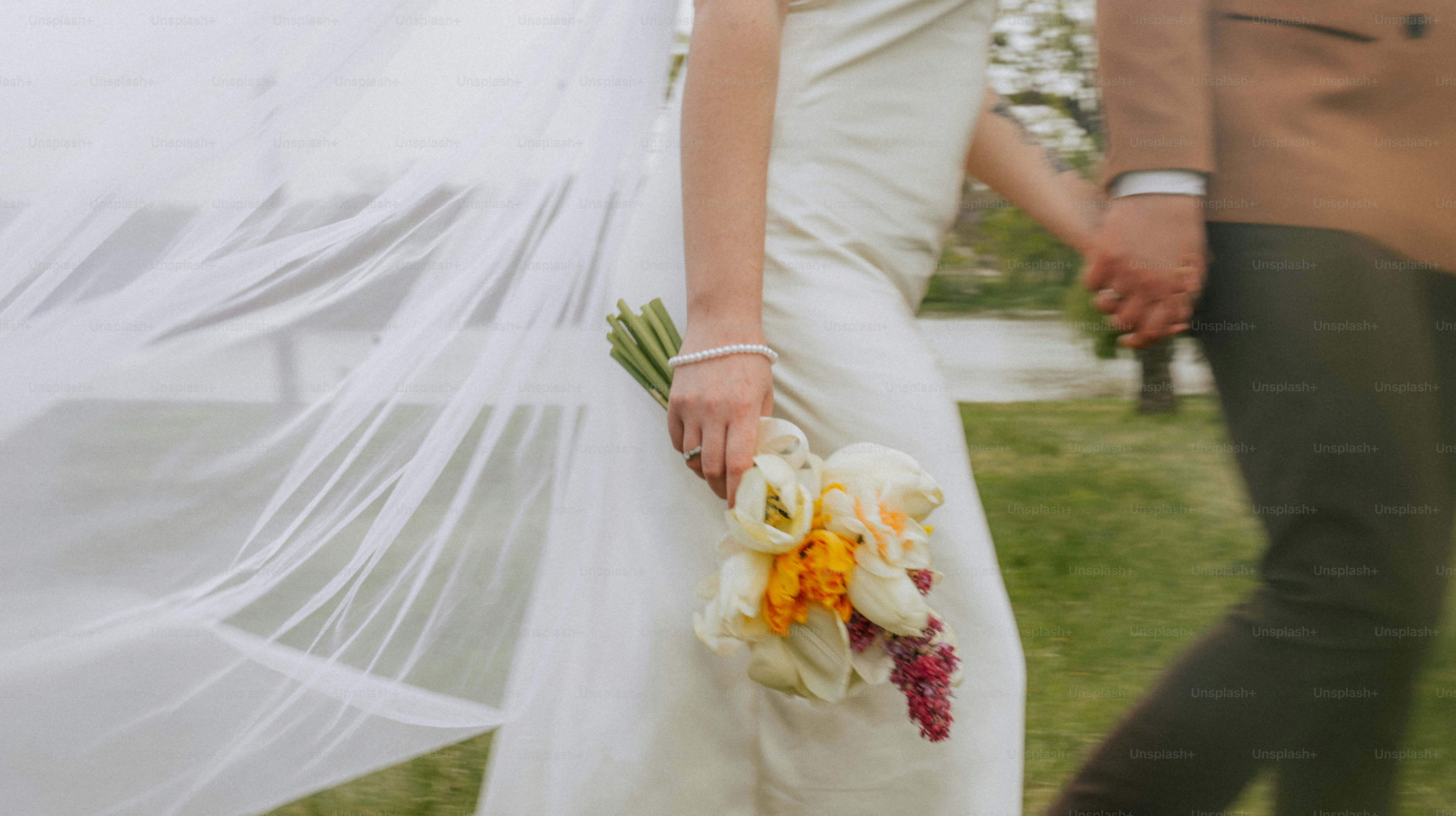 Bride and groom holding hands with wedding bouquet