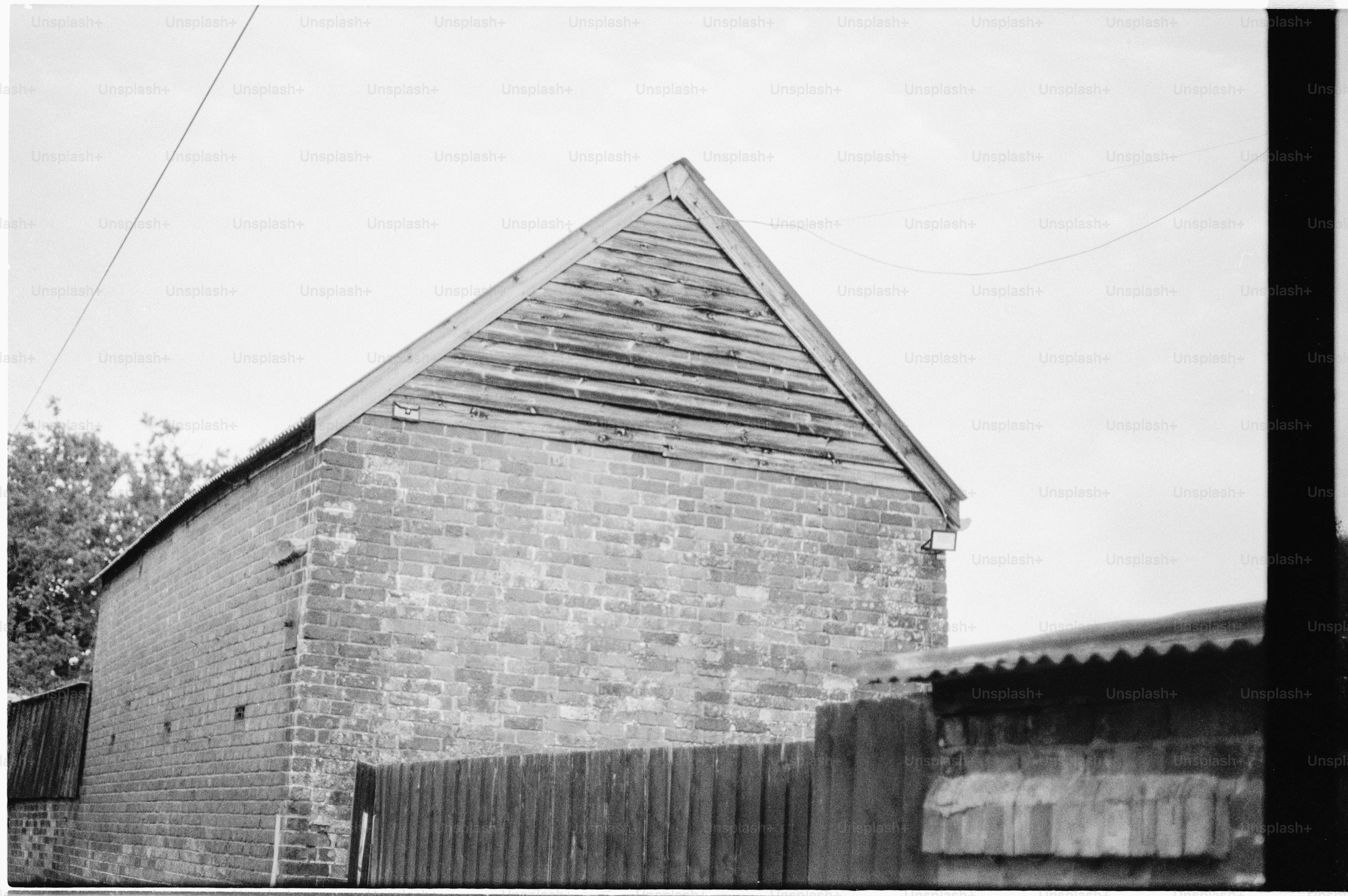 Brick building with wooden siding under a clear sky.