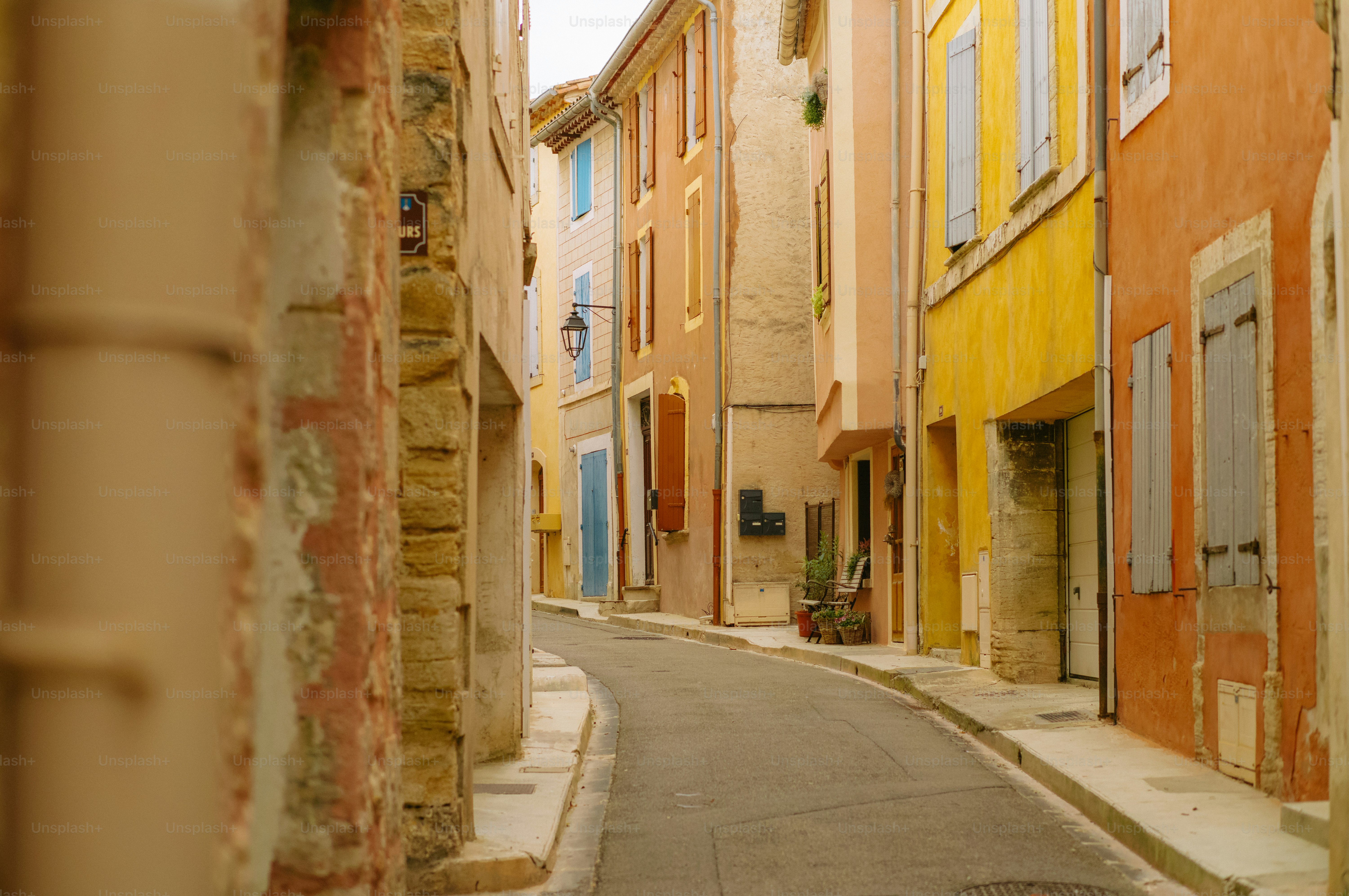 Narrow cobblestone street lined with colorful buildings.