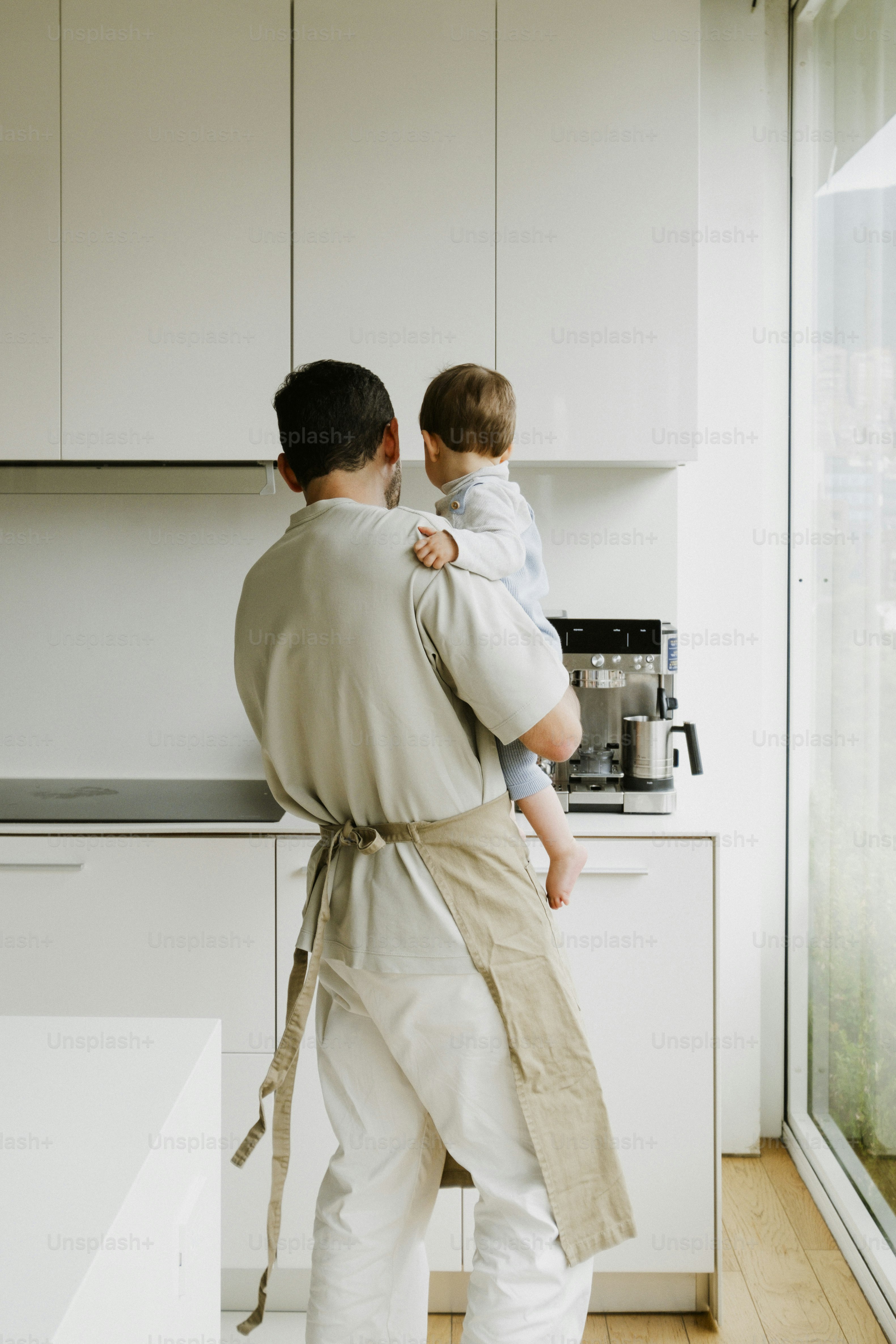 Father holding a baby in a modern kitchen
