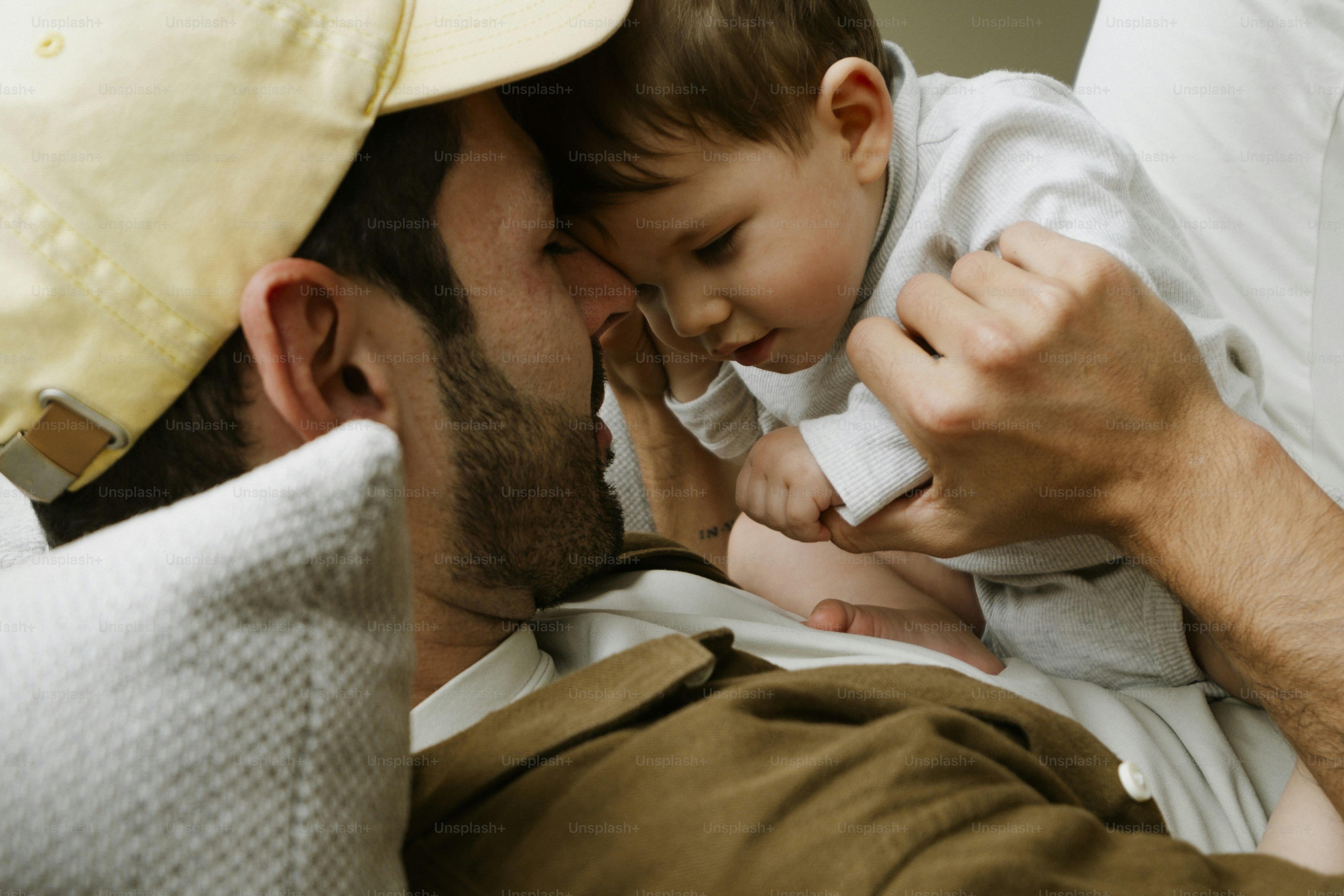 A man and a baby touching foreheads affectionately.