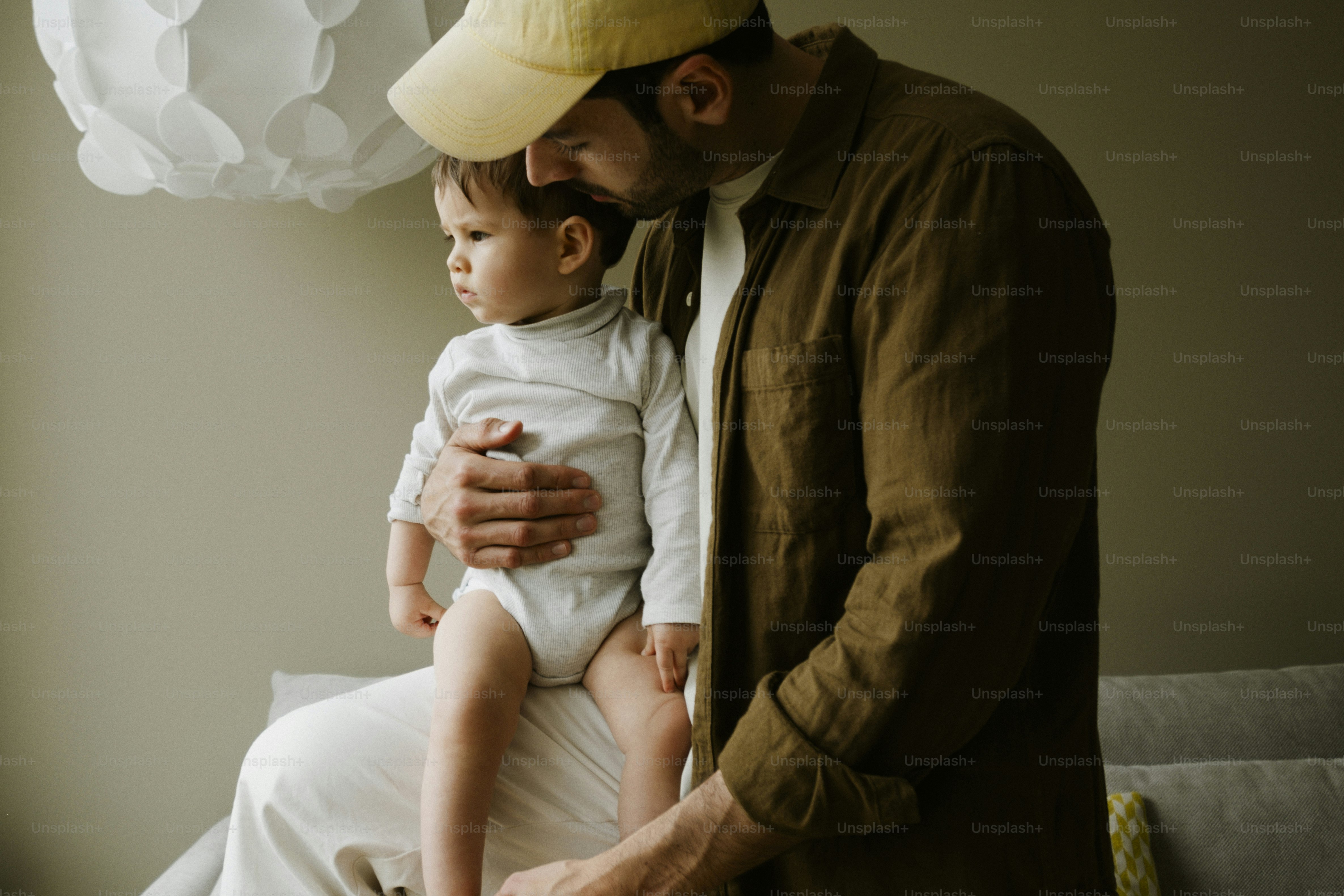 Father holding his baby son indoors.