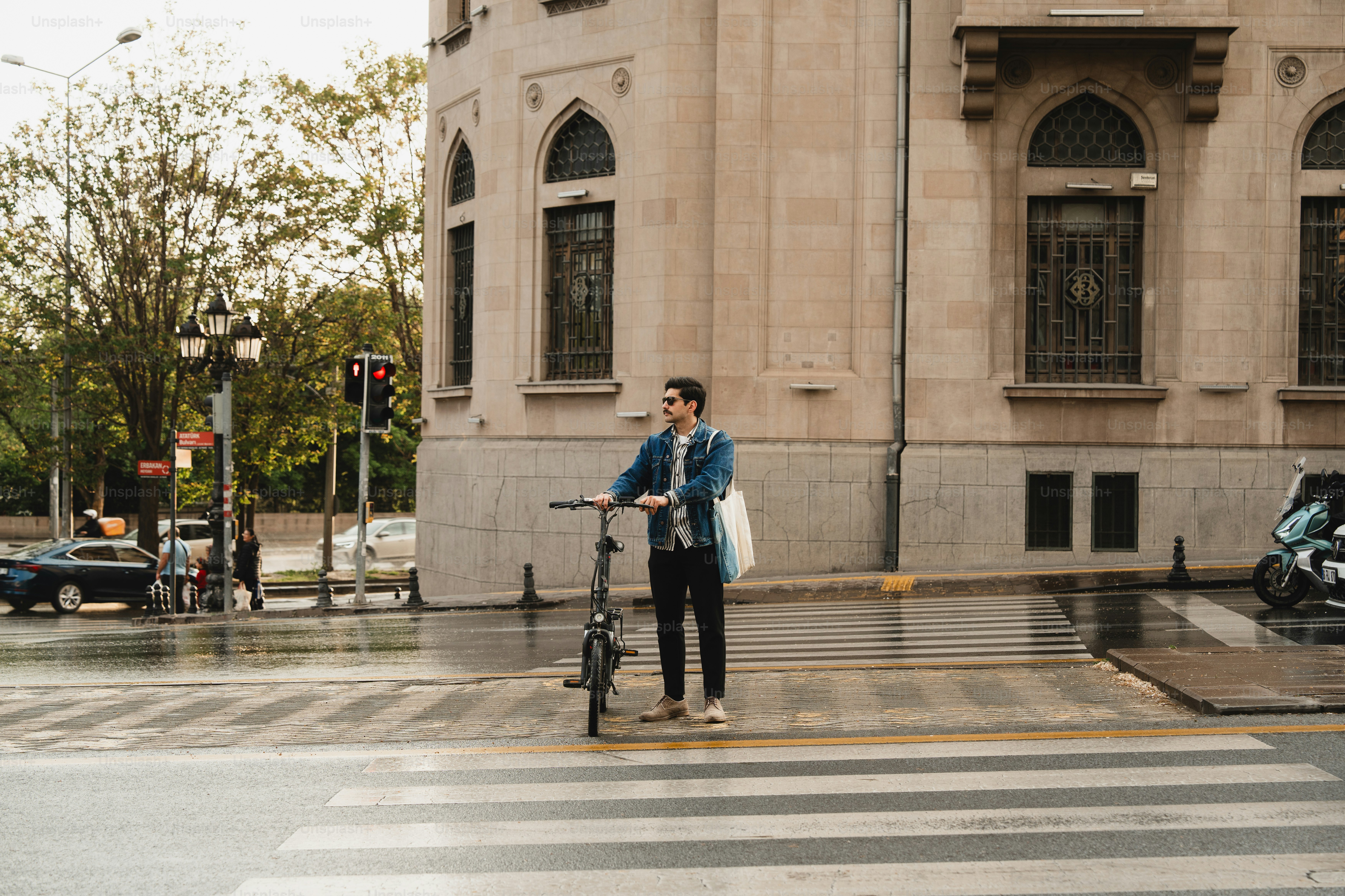 Hombre con bicicleta en un cruce de calle de la ciudad.