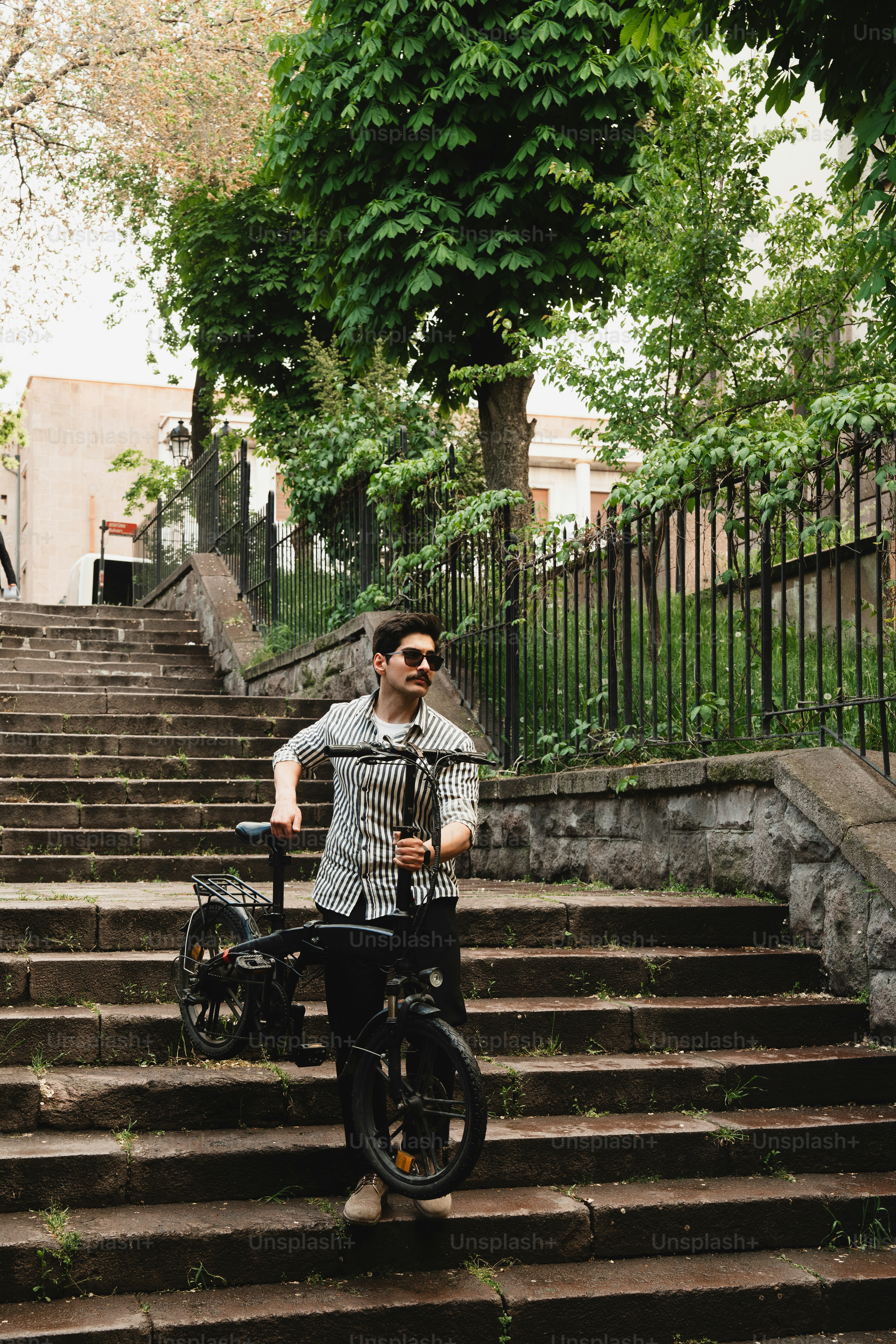 Hombre con bicicleta en las escaleras de piedra exteriores