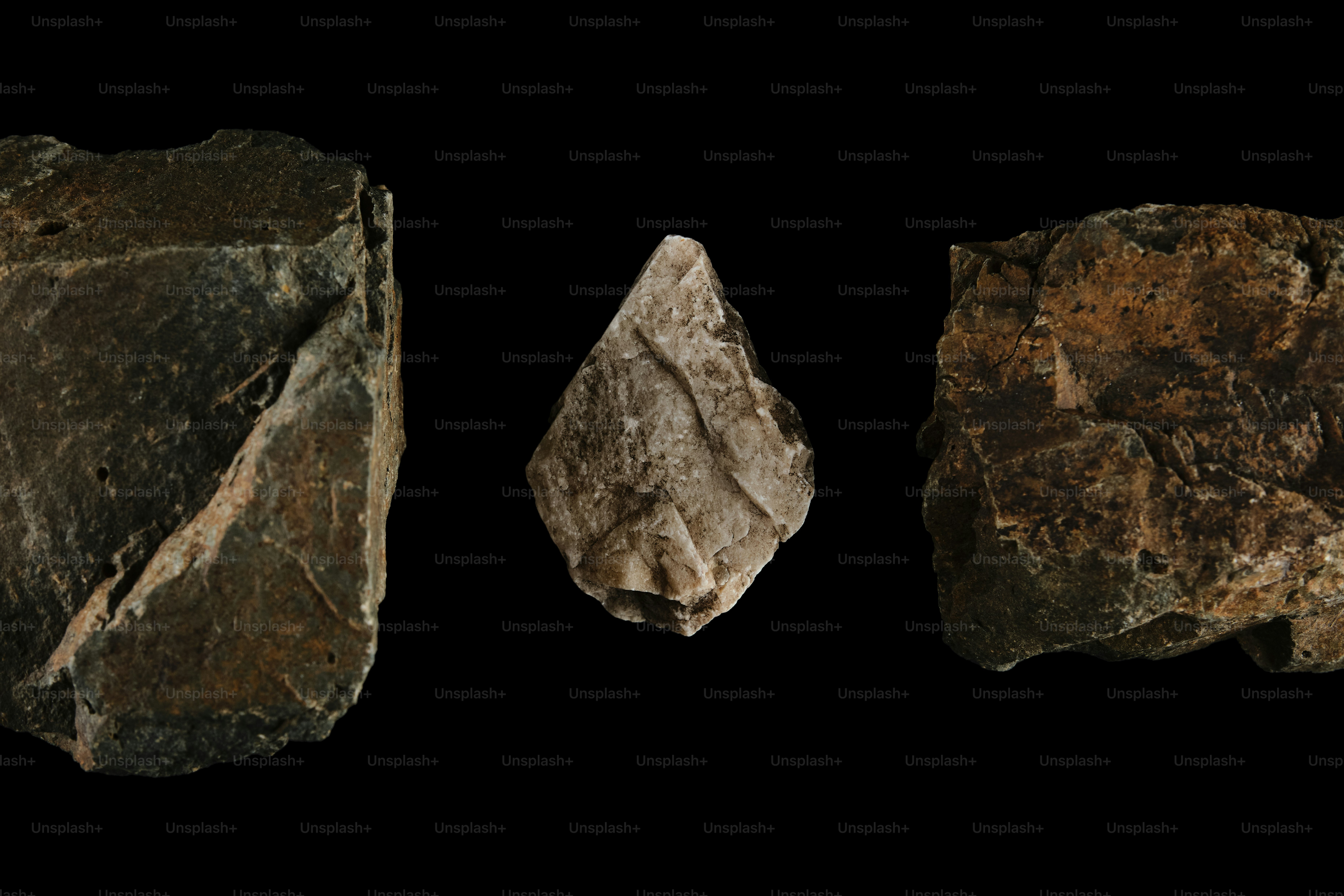Three ancient stone tools on black background