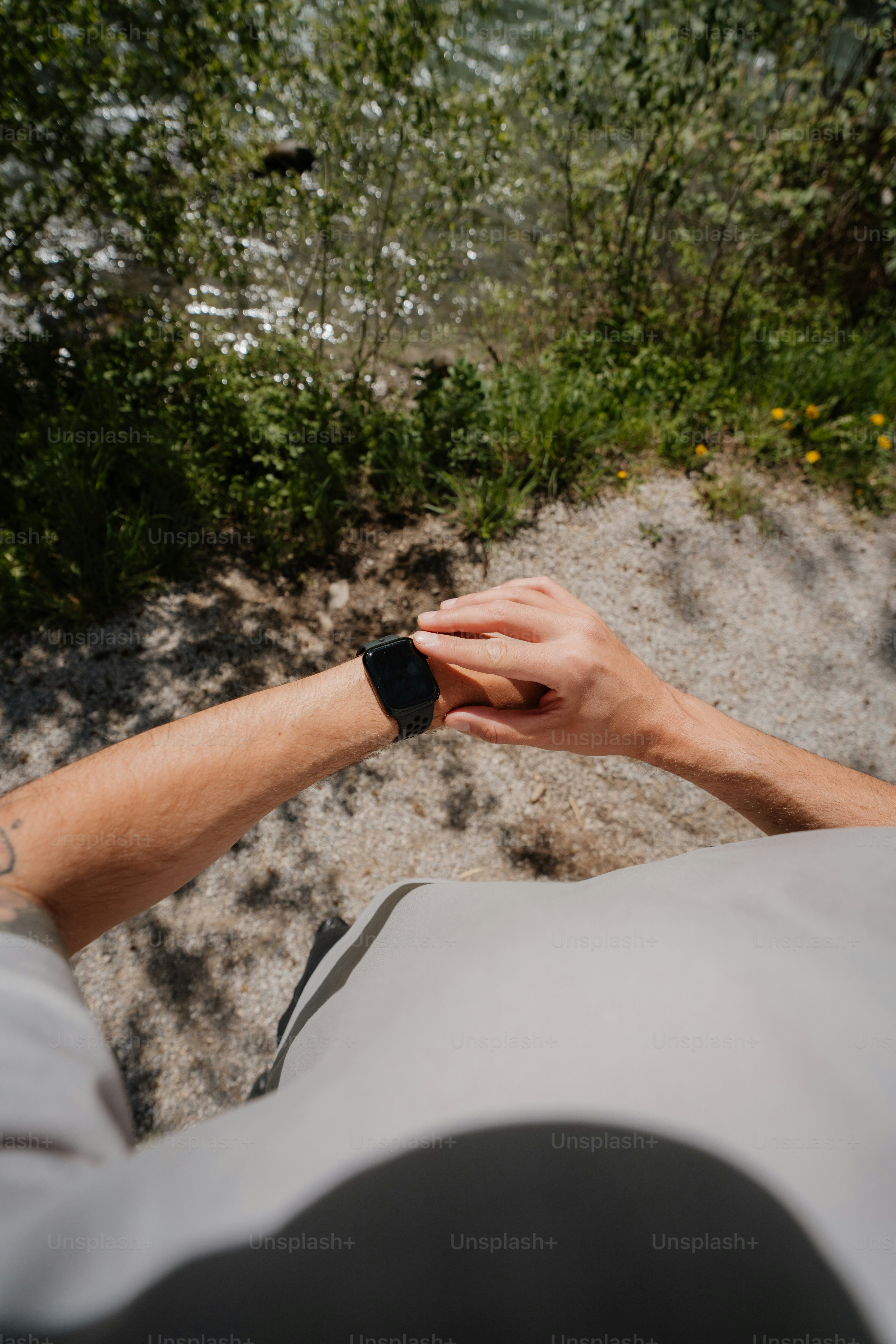 Pessoa checando smartwatch ao ar livre perto de um corpo d'água