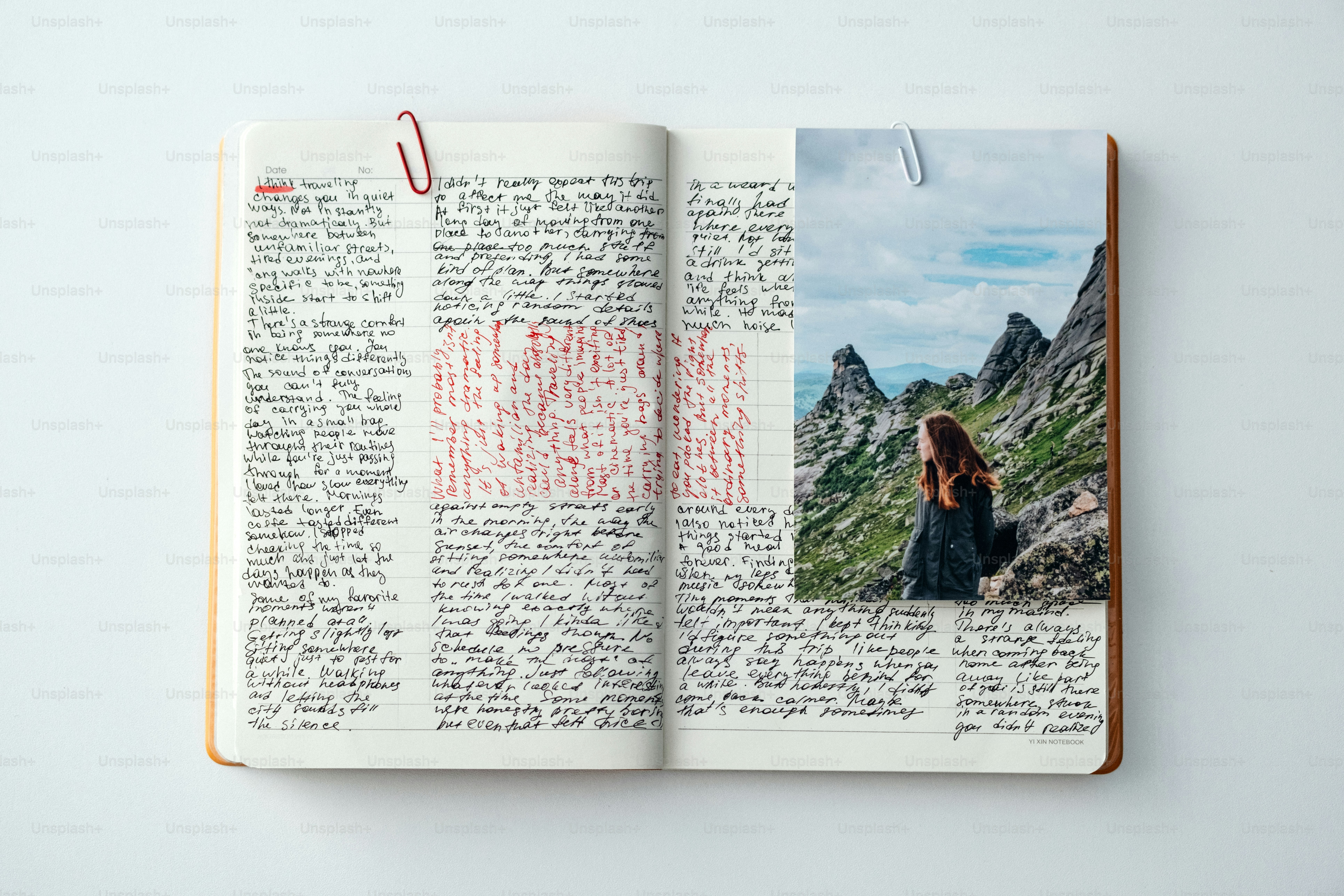 Journal ouvert avec des notes manuscrites et une photo de montagne.